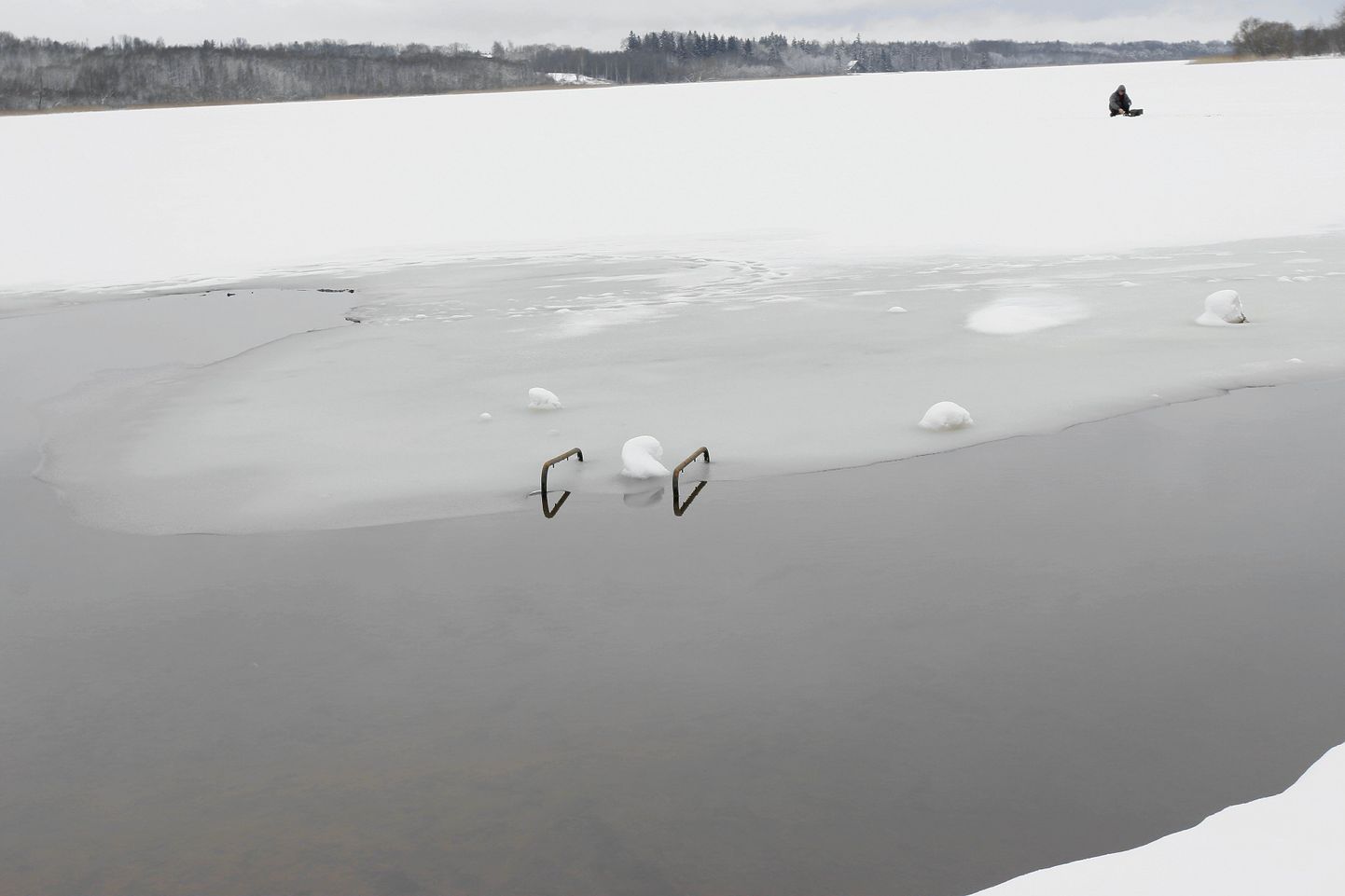 Huntaugu rannas on koht, kuhu sinna suubuva oja tõttu jääd ei teki. Taamal istuva kalamehe juures on jää paksus aga 30 sentimeetrit.