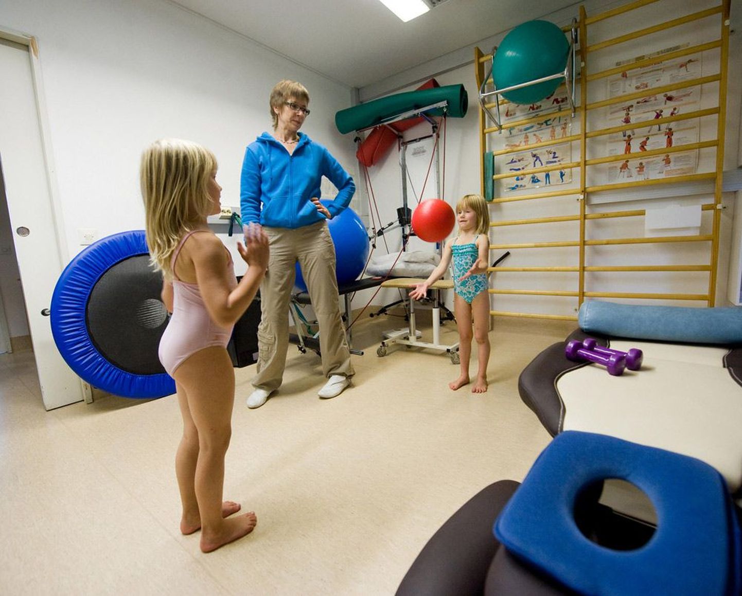 Эрет Тийтинен с дочкой Тайкой (справа) и соседской девочкой Илоной в своем физиотерапевтическом кабинете в Пиексямяки.