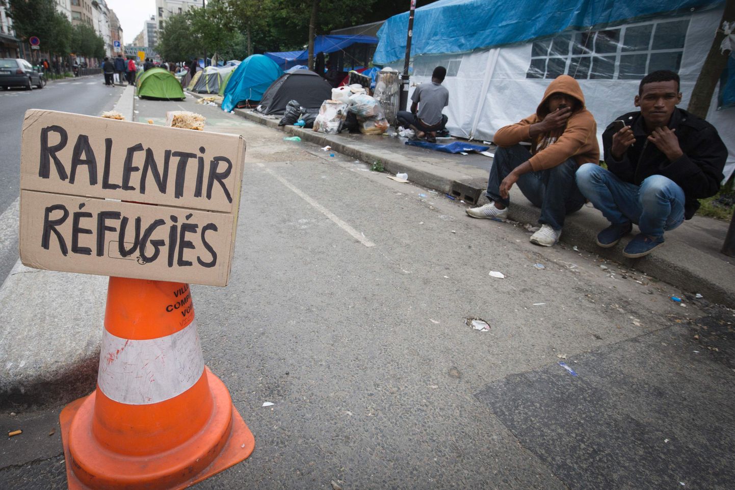«Aeglustage, põgenikud» silt Jardins d'Eole'i põgenike poolt püsti pandud laagri ees