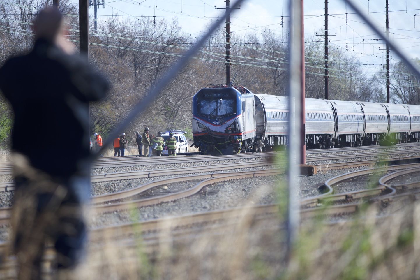 CHESTER, PA - APRIL 3: A man observes the crash site of Amtrak Palmetto train 89 on April 3, 2016 in Chester, Pennsylvania. Two people are confirmed dead after the lead engine of the train struck a backhoe that was on the track sourth of Philadelphia, according to published reports. Approximately 341 passengers and seven crew members were onboard the train, which was traveling from New York to Savannah, according to Amtrak.   Mark Makela/Getty Images/AFP
== FOR NEWSPAPERS, INTERNET, TELCOS & TELEVISION USE ONLY ==