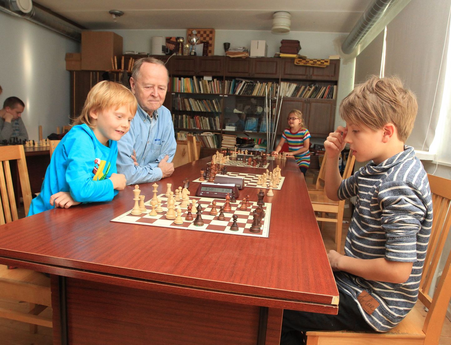 Vasakul mängib Albert Pedmanson, tema kõrval istub maletreener Aleksei Rei. Paremal on Jürgen Güsson.