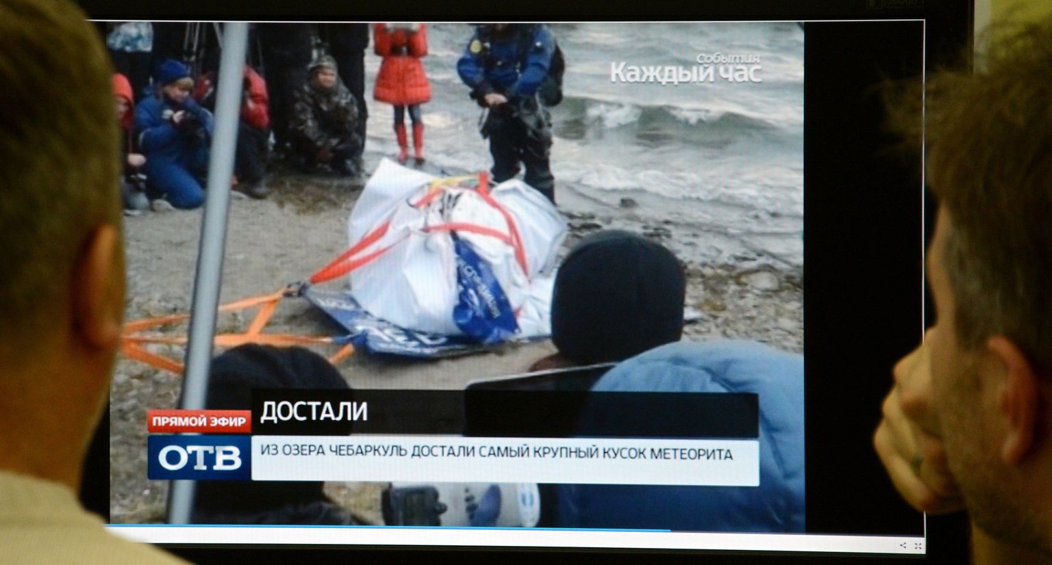 Mehed uurivad arvutiekraanilt fotot Tšeljabinski meteoriidi suurimast tükist.