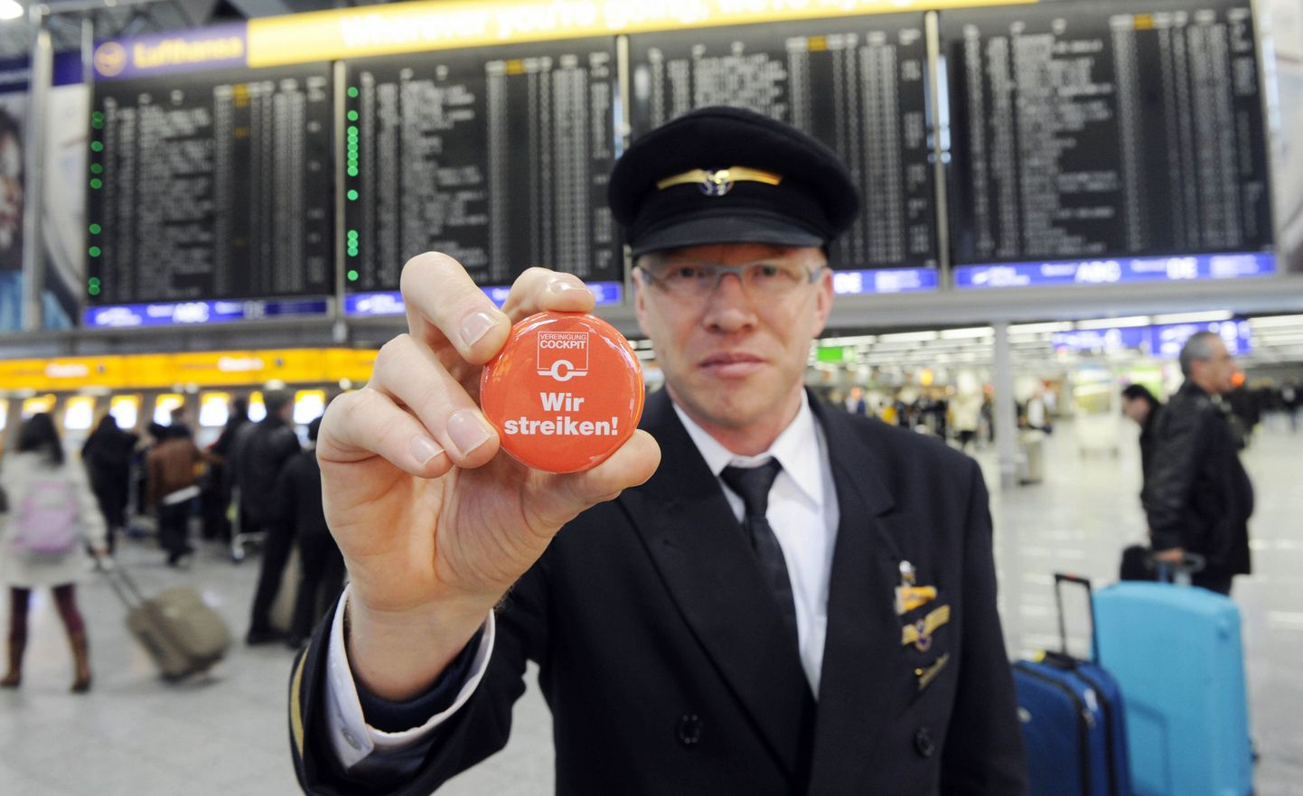 Пилот Lufthnsa Эрнст ван Корт показывает значок с надписью "Мы бастуем".