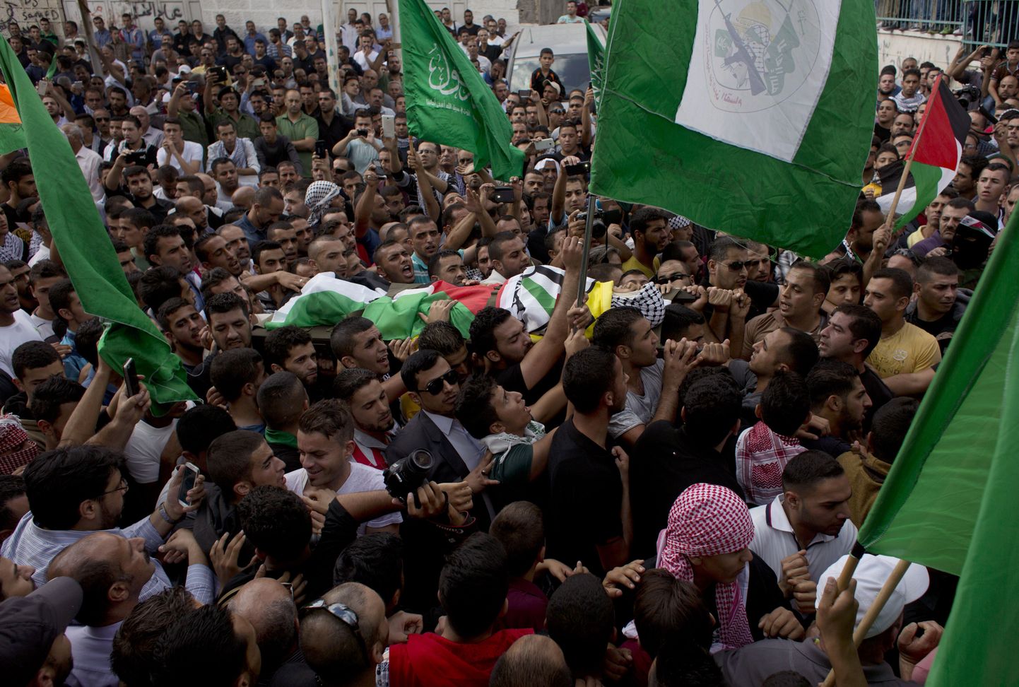 Участники протестов несут на кладбище тело 13-летнего Абделя Рахмана Шади, застреленного израильскими солдатами.