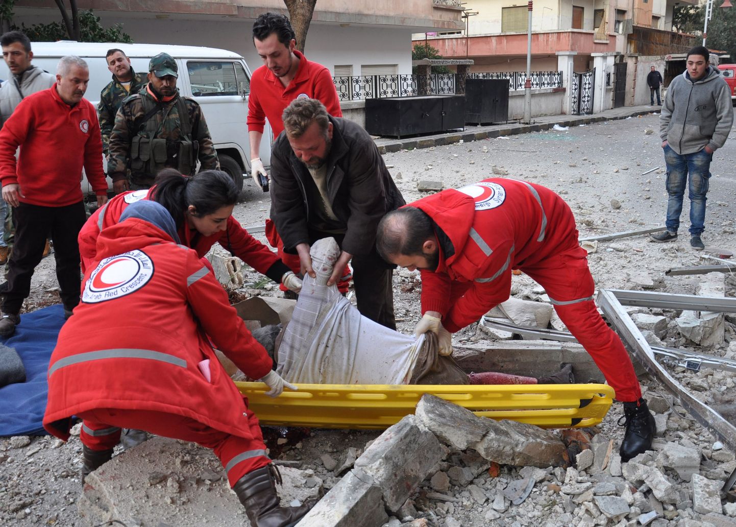 Süüria Punane Rist Homsi linnas pommitamises hukkunud mehe keha eemaldamas.