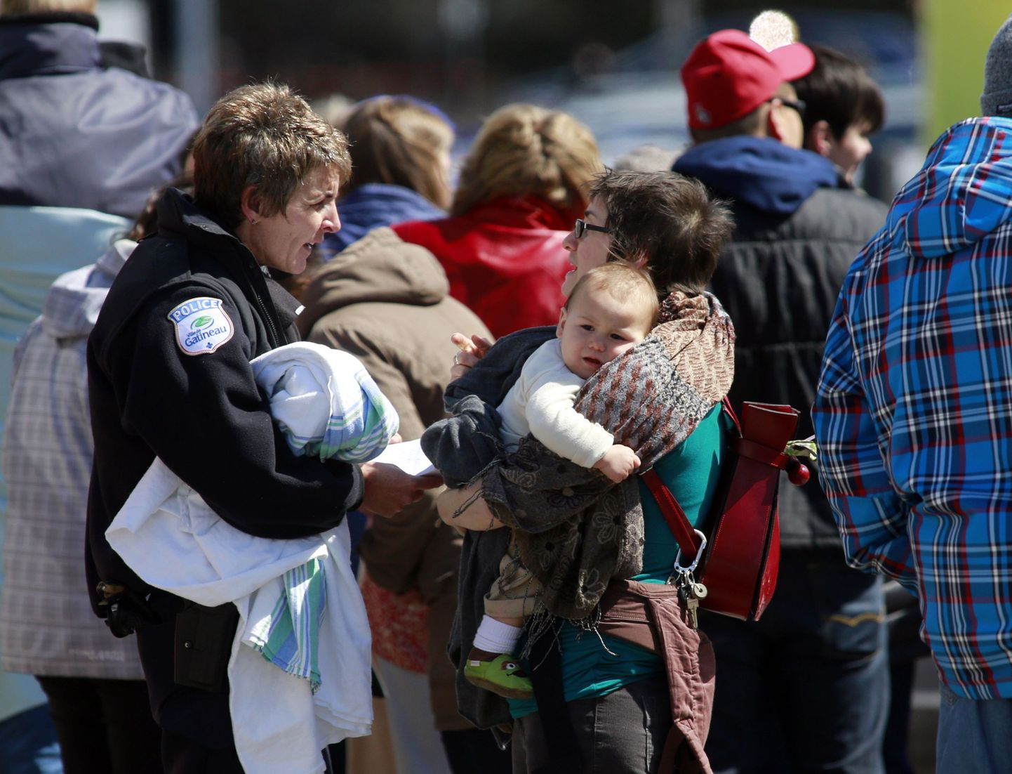 Quebeci politseinik vestleb väikest last süles hoidva naisega tulistamispaiga lähistel Gatineau's.
