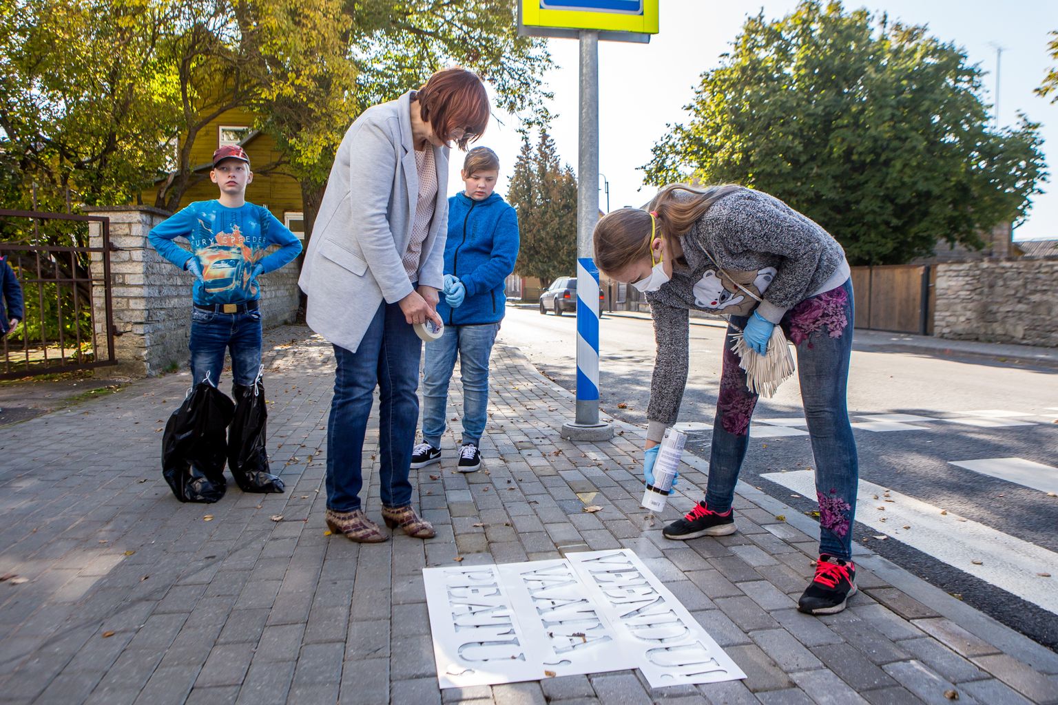 OHTLIK ÜLEKÄIGURADA: 6.b klass märgistas kõnnitee Pika tänava ülekäiguraja mõlemad otsad. Pildile jäid klassijuhataja Külli Põldma, Janar Sepp, Alice Jürisson ja parasjagu värvi pihustanud Triinu Kull.
