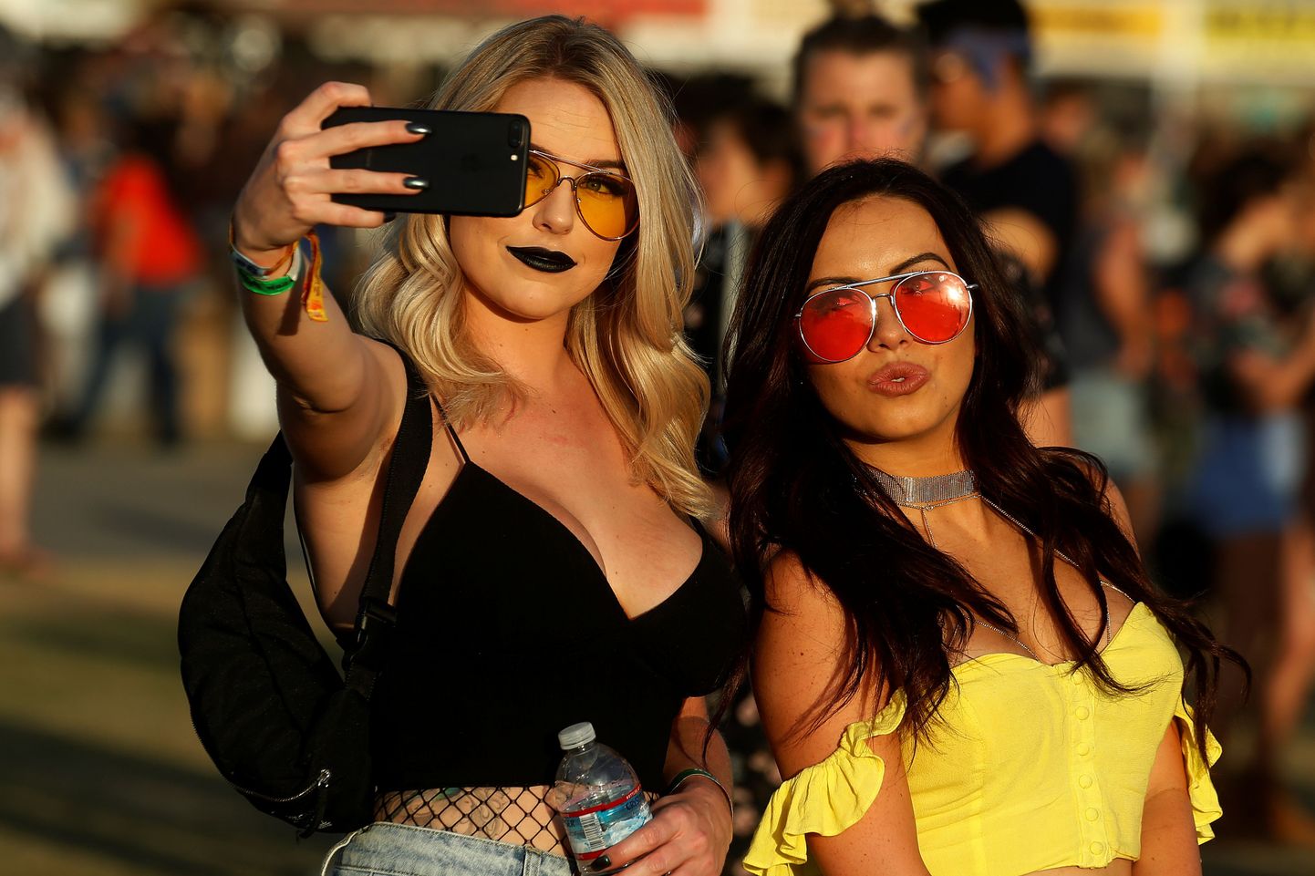 Women take a photo in the late afternoon sun during the Coachella Valley Music and Arts Festival in Indio, California, U.S. April 16, 2017.   REUTERS/Carlo Allegri