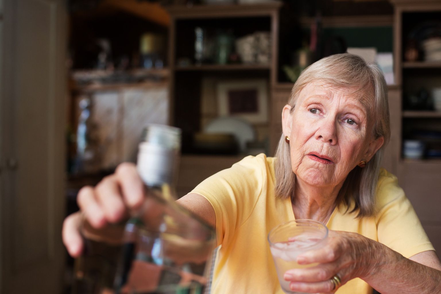 Woman reaching for bottle of liquor