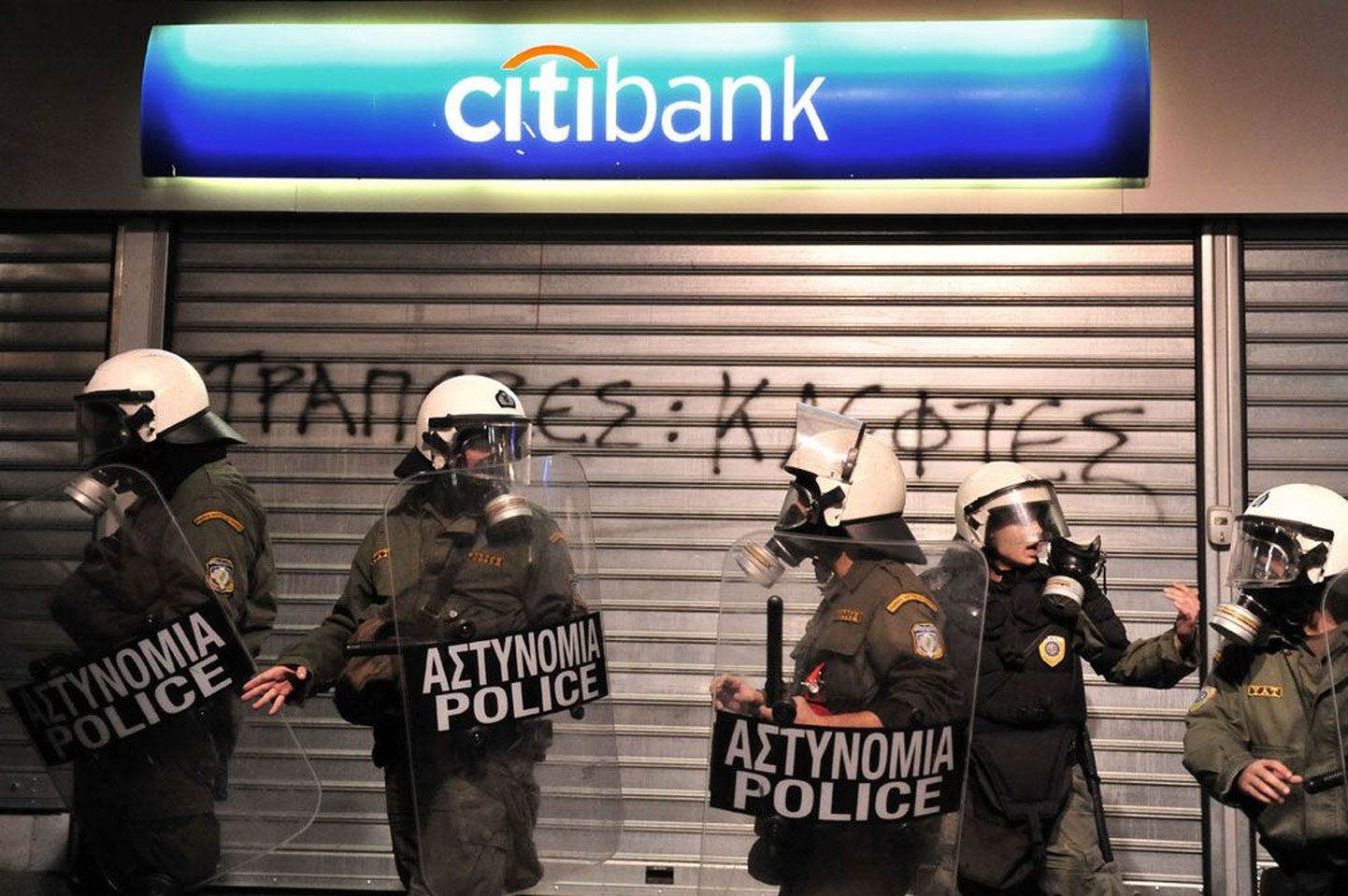 Kreeka 23. märtsil 2010: märulipolitsei  valvamas suletud pangahoonet riigiametnike meeleavalduse ajal. Viimased protestivad valitsuse kärpekavade vastu.