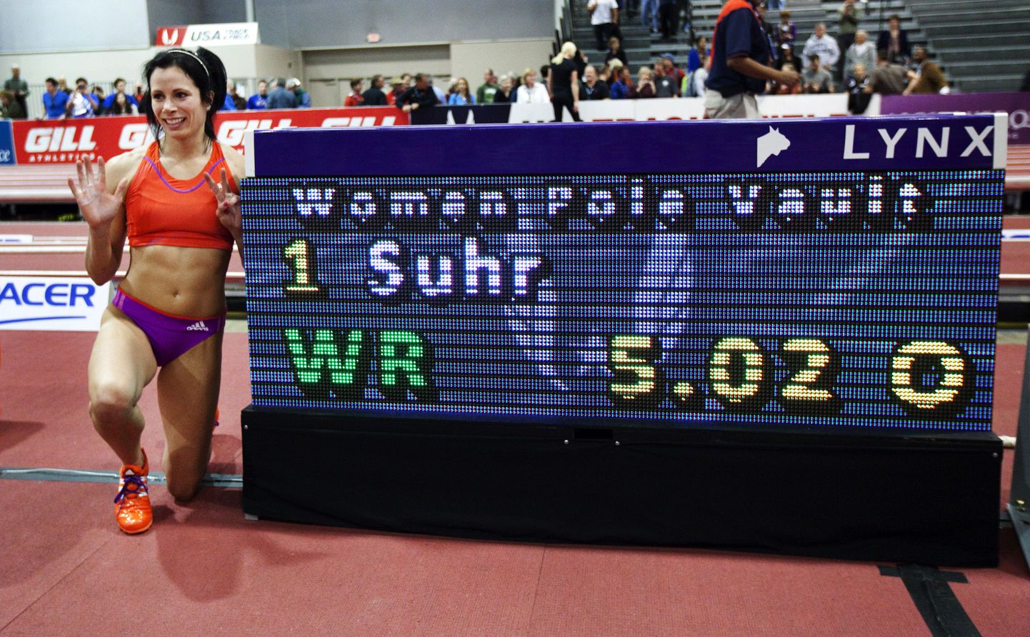 Jenn Suhr poseerimas koos maailmarekordiliste numbritega.