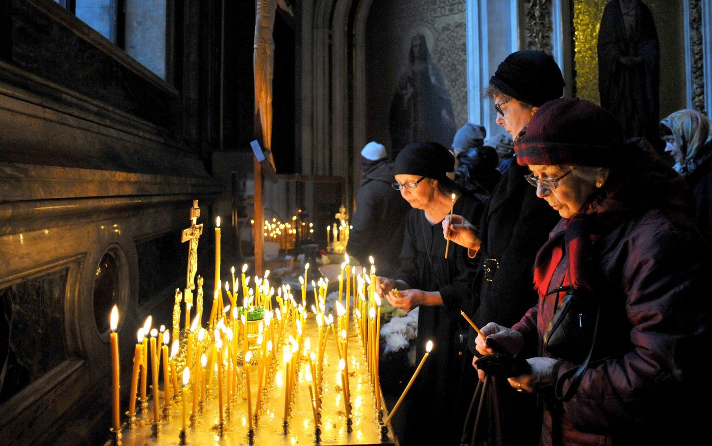 Kirikulised süütavad Peterburi Püha Iisaku katedraalis küünlaid, et mälestada lennukatastroofis hukkunuid.