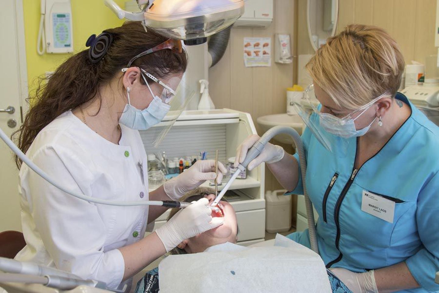Veronika Denõssenko tööpostil Viljandi hambakliinikus. Paremal hambaarsti abiline Margit Laos.