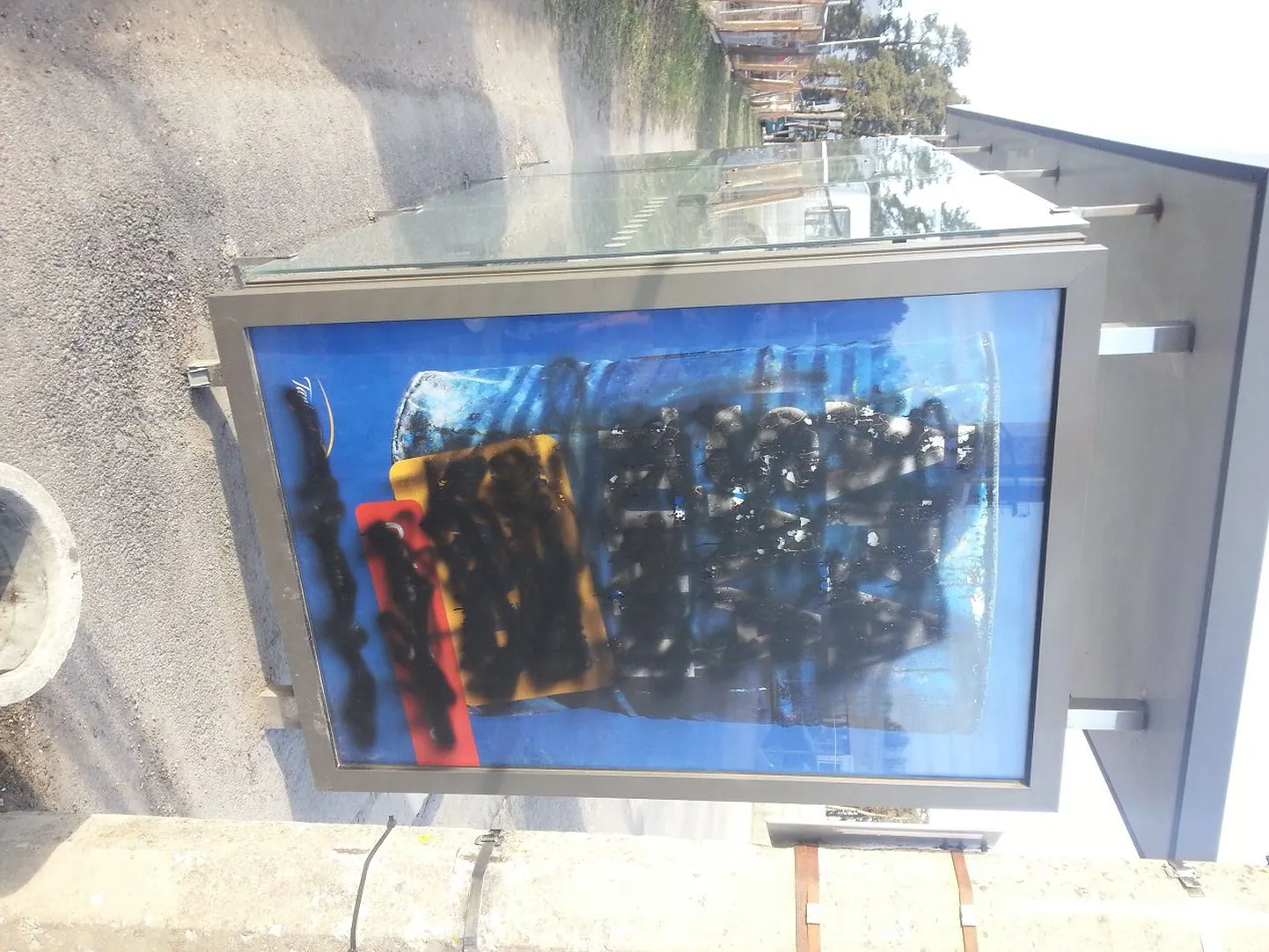Испачканный черной краской автобусный павильон.