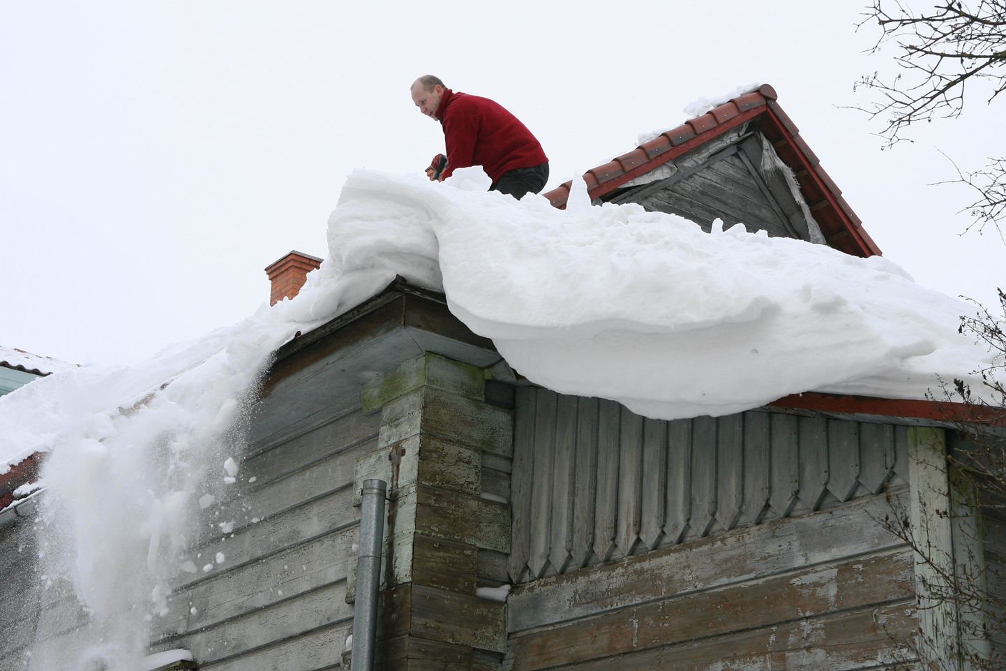 Katuse puhastamine lumest. Foto on illustreeriv.