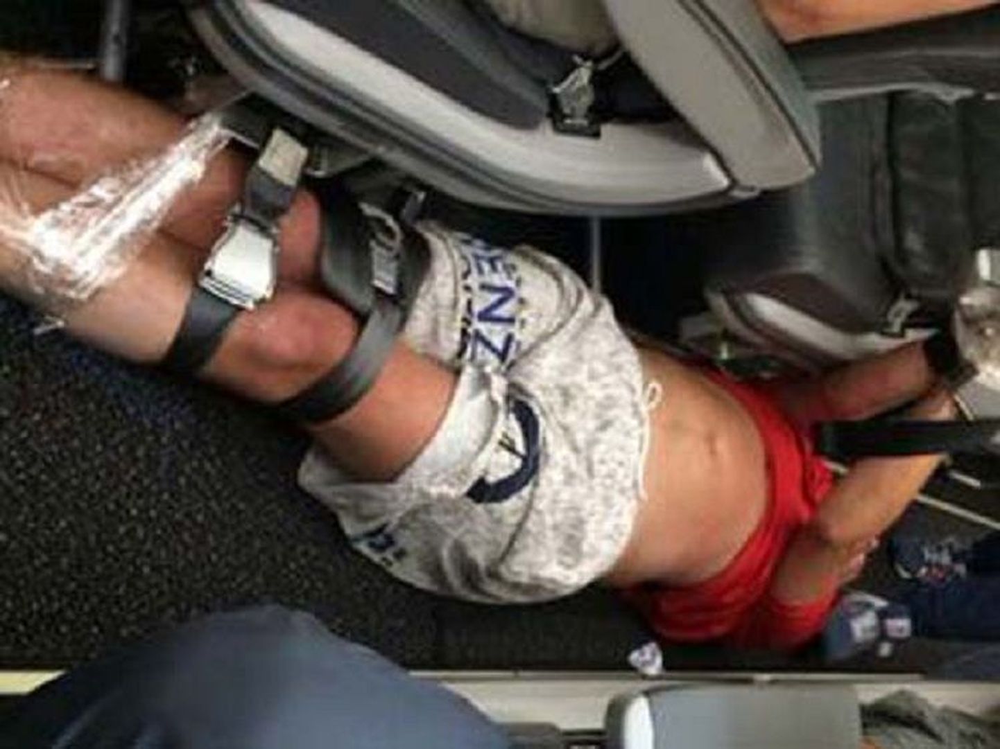 Фото сделано на рейсе Гонконг-Владивосток, где разбушевавшегося пассажира пришлось связать скотчем и ремнями.