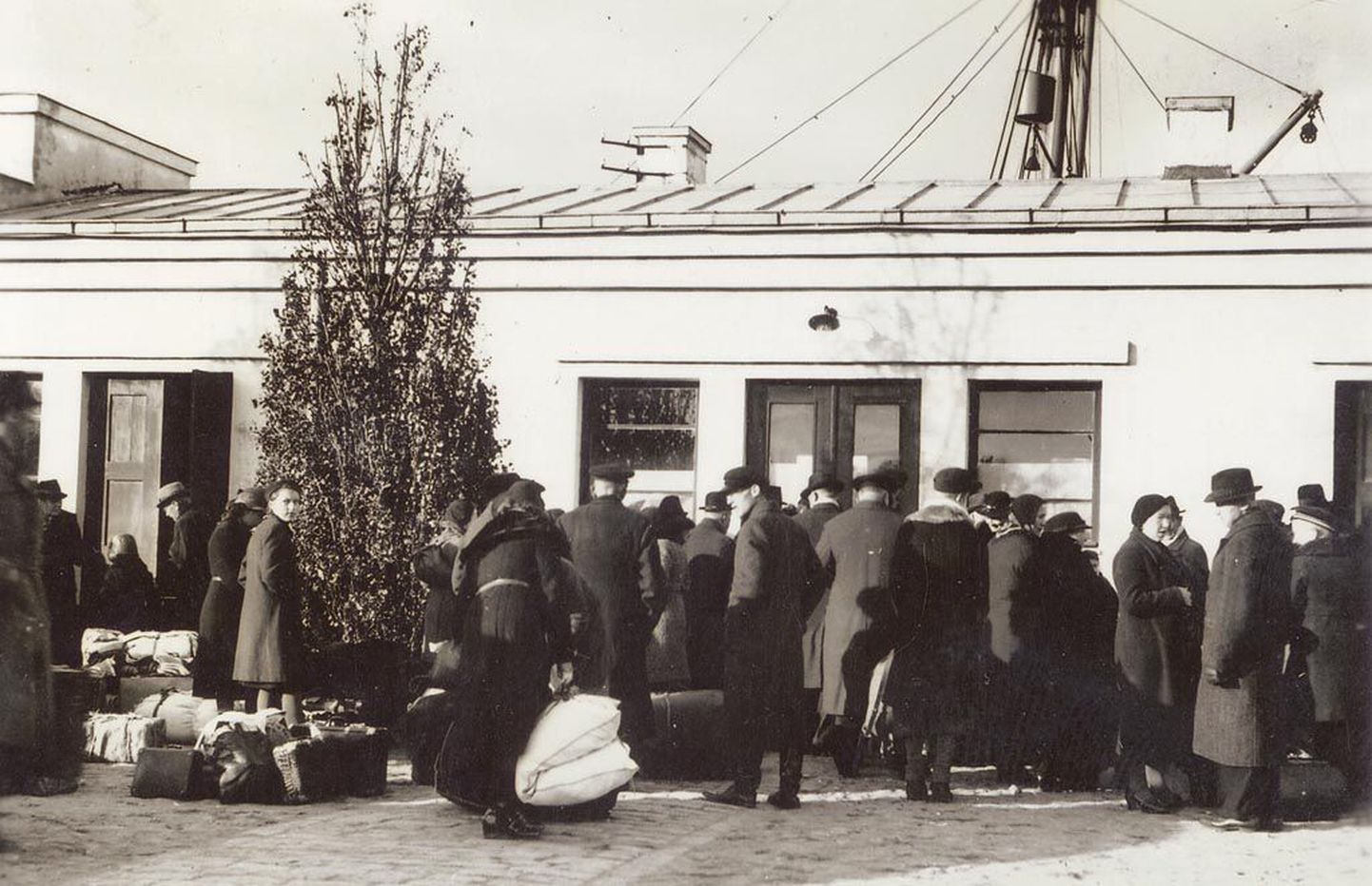 Saksa ümberasujad Pärnu sadama reisijatehoone juures. Maja on alles praegugi.