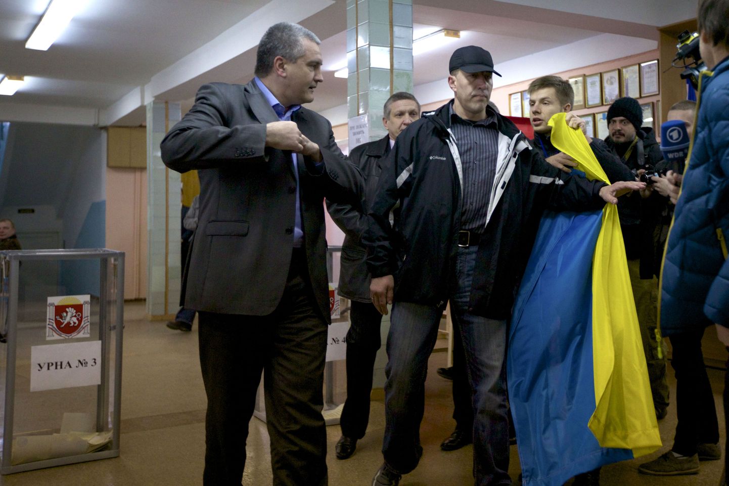 Sergei Aksjonovi (vasakul) hääletamist segas valimisjaoskonda Ukraina lipuga saabunud mees.