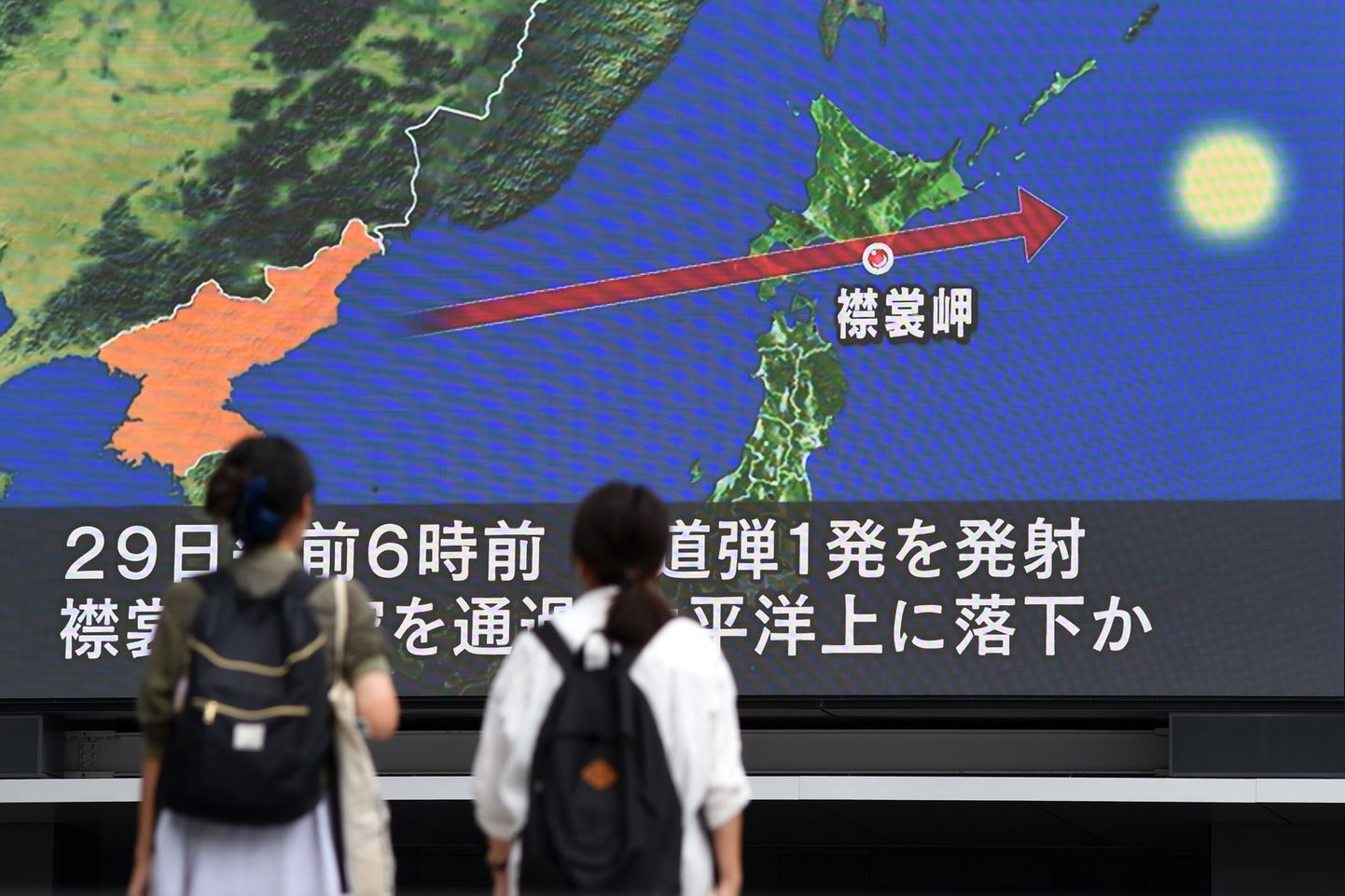 Jalakäijad Jaapanis suurelt ekraanilt uudist raketi kohta lugemas.