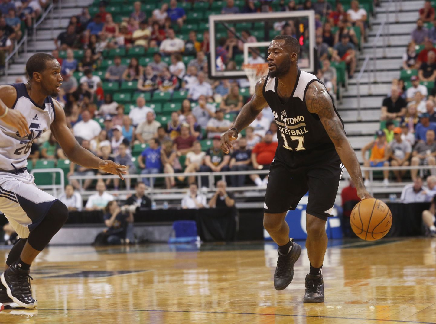 San Antonio Spurs' Jonathan Simmons (17) dribbles down the court as Utah Jazz's Dionte Christmas (26) defends during the first half of an NBA Summer League basketball game Monday, July 4, 2016, in Salt Lake City. (AP Photo/Kim Raff)