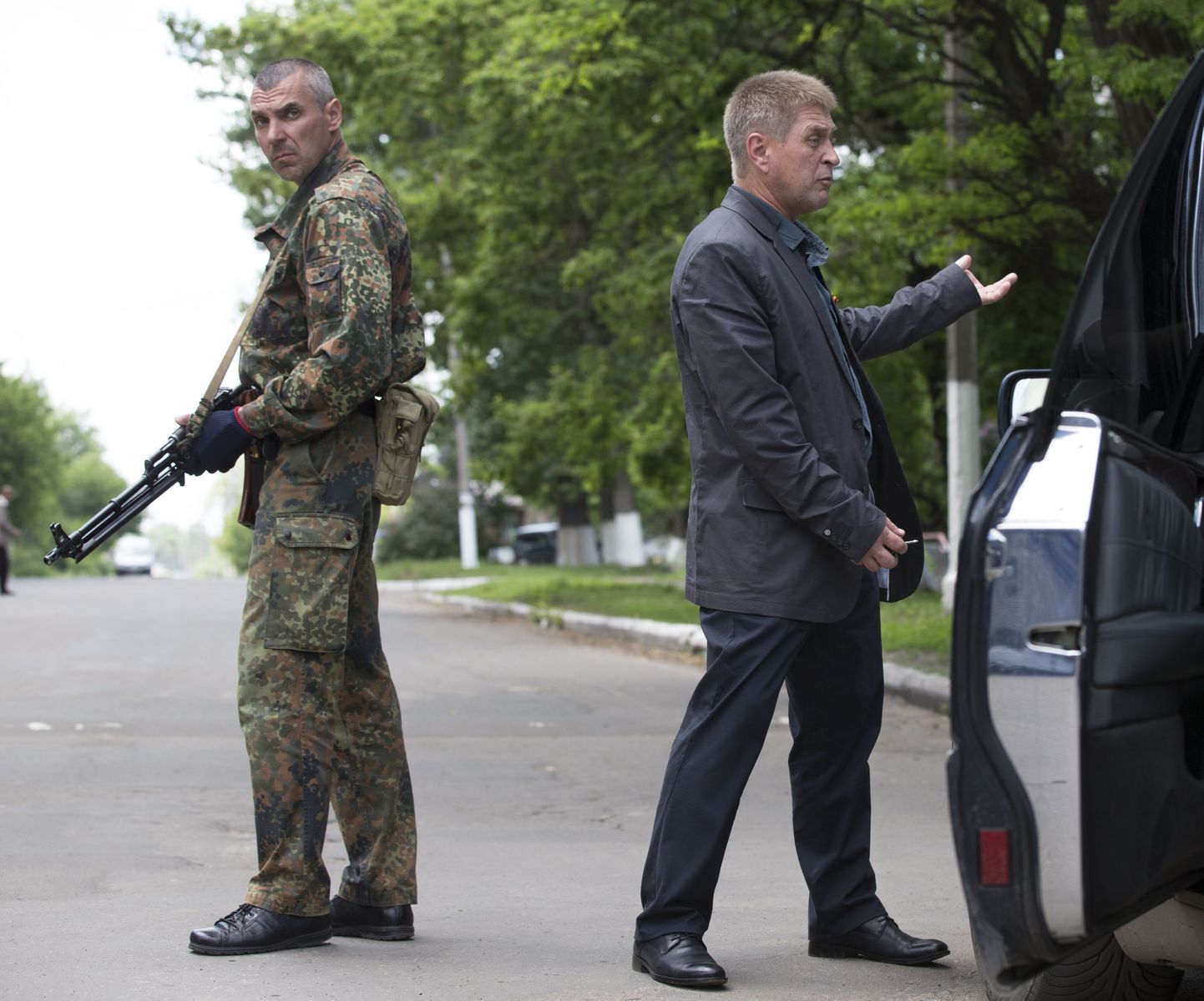 Slovjanski isehakanud meer Vjatšeslav Ponomarjov (paremal) seisab oma auto juures. Vasakul on relvastatud separatist.