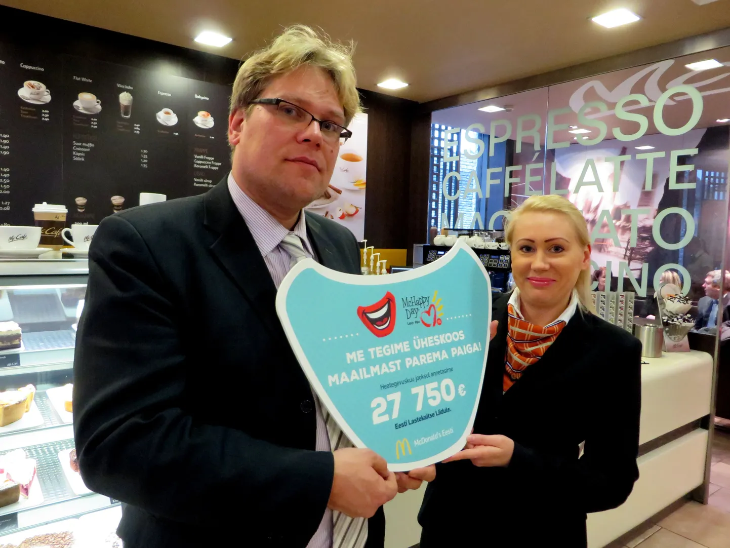 Lastekaitse liidu juht Martin Medar võtab vastu restoranikülastajate annetatud summaga tšeki.