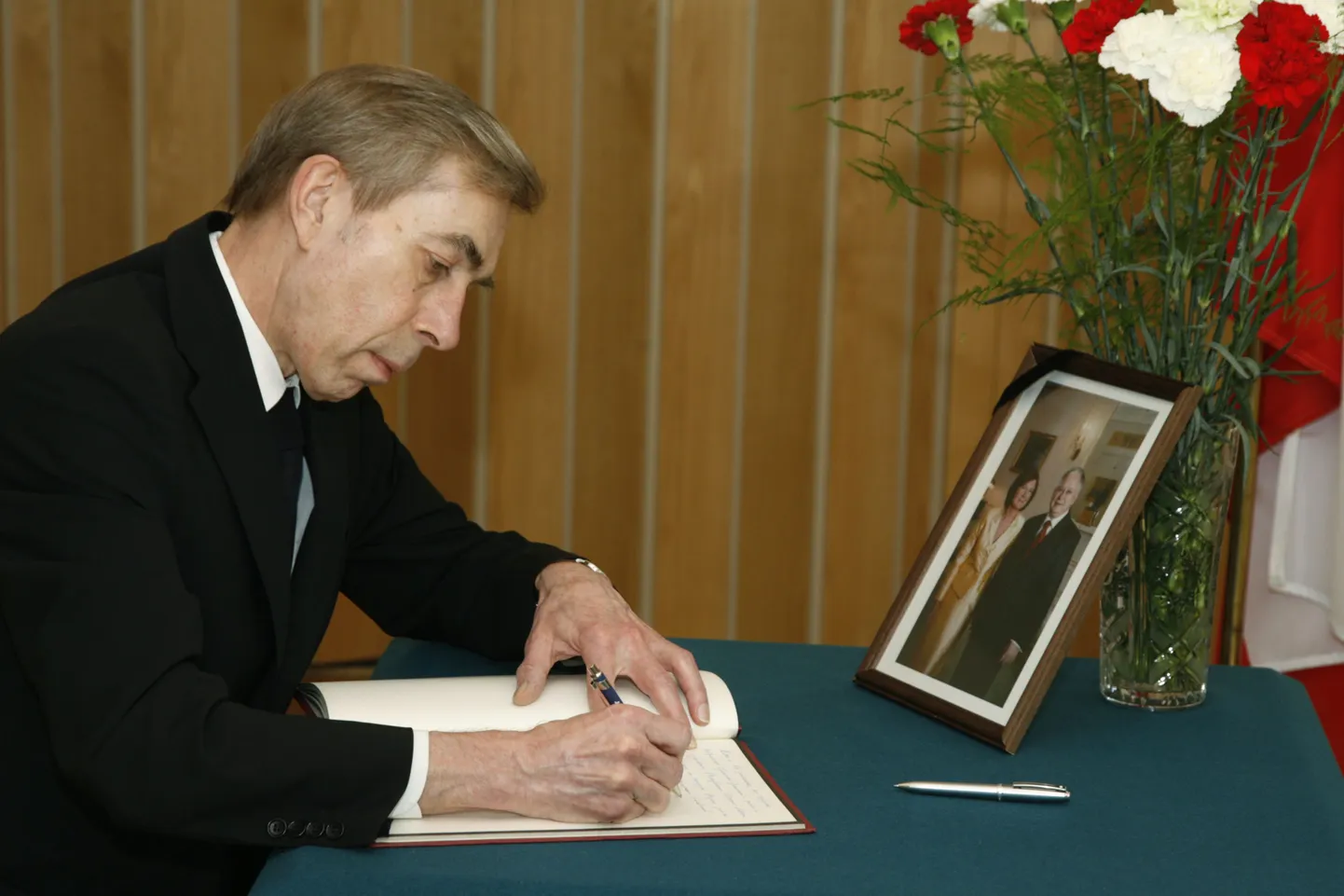 Посол РФ Николай Успенский делает запись в книге соболезнований.