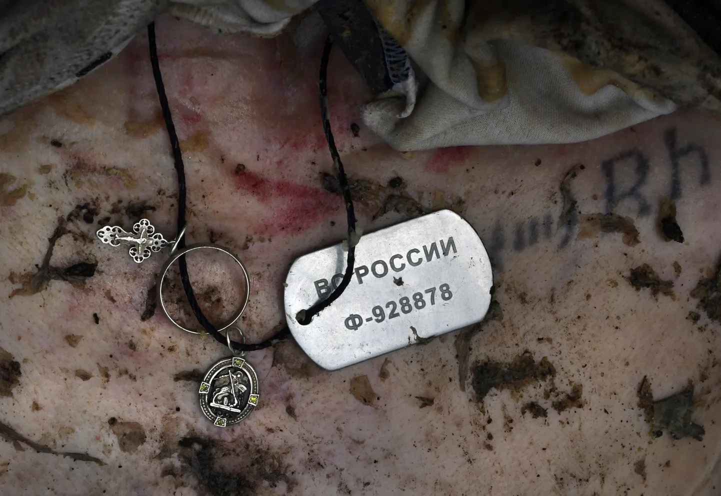 Военный жетон на теле мертвого солдата ВС РФ, апрель 2022 года, Буча, Украина.