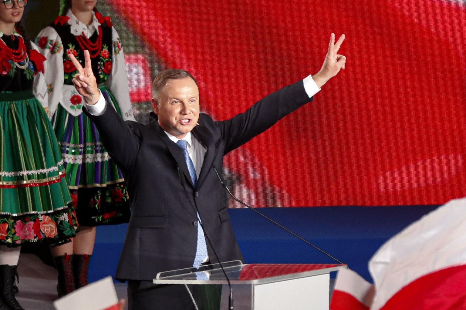 Poola president Andrzej Duda näitab pühapäeva õhtul Łowiczis kätega võidumärki pärast edukat esimest hääletusvooru, kus teda toetas üle 40 protsendi valijatest.