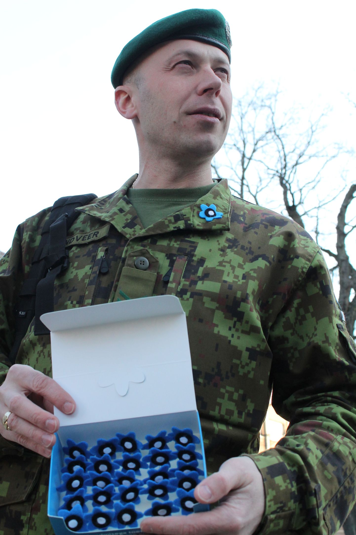 Vanemveebel Rando Randveer näitab veteranipäeva tähistavaid sinililli. Kaitsevägi