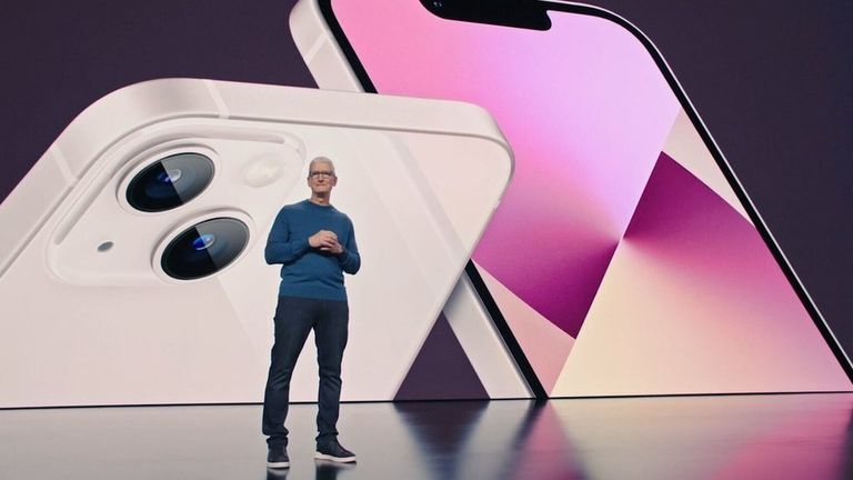 Глава Apple Тим Кук во время презентации на фоне снимка iPhone 13
