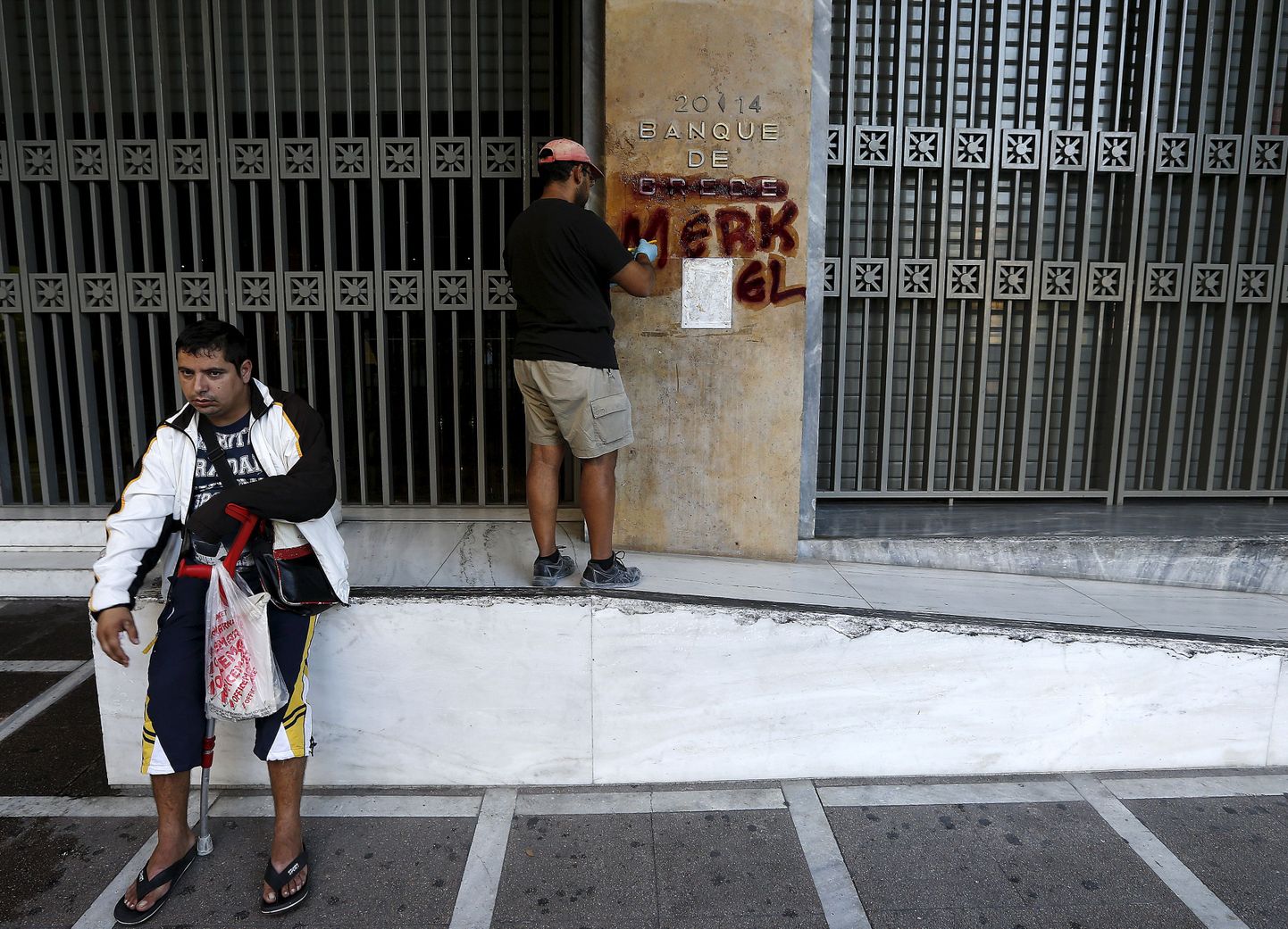 Tööline täna Kreeka keskpangalt graffitit puhastamas.