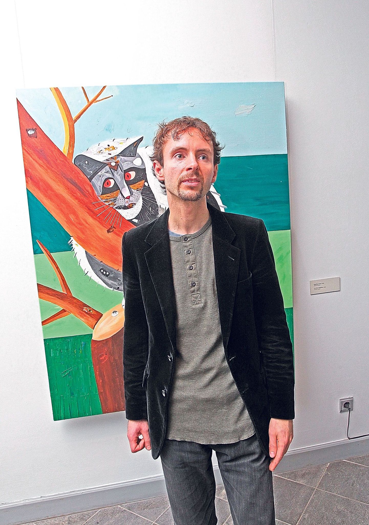 August Künnapu (35) rääkis oma maalidest ja raamatust Tartu kunstimuuseumi esimesel korrusel näituse avamisel, selja taga «Supilinna kass» (2013, akrüül lõuendil).