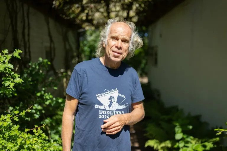 Andres Mustonen oma Tallinna kodu aias, seljas varakevadel Iisraelis toimunud MustonenFesti kirjaga särk.