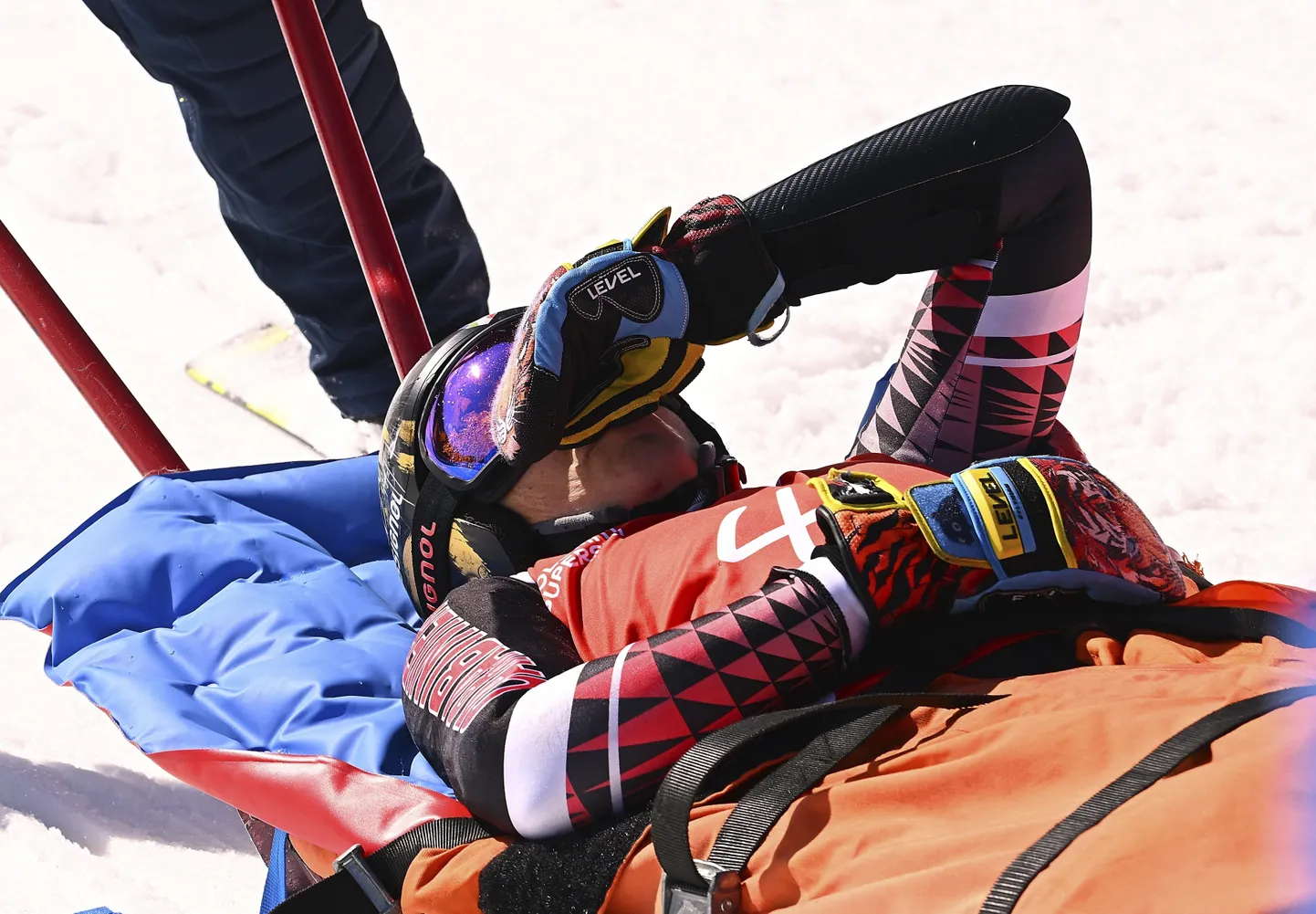 Vigastada saanud Federica Brignone kanderaamil ja ootamas helikopteriga transportimist haiglasse.