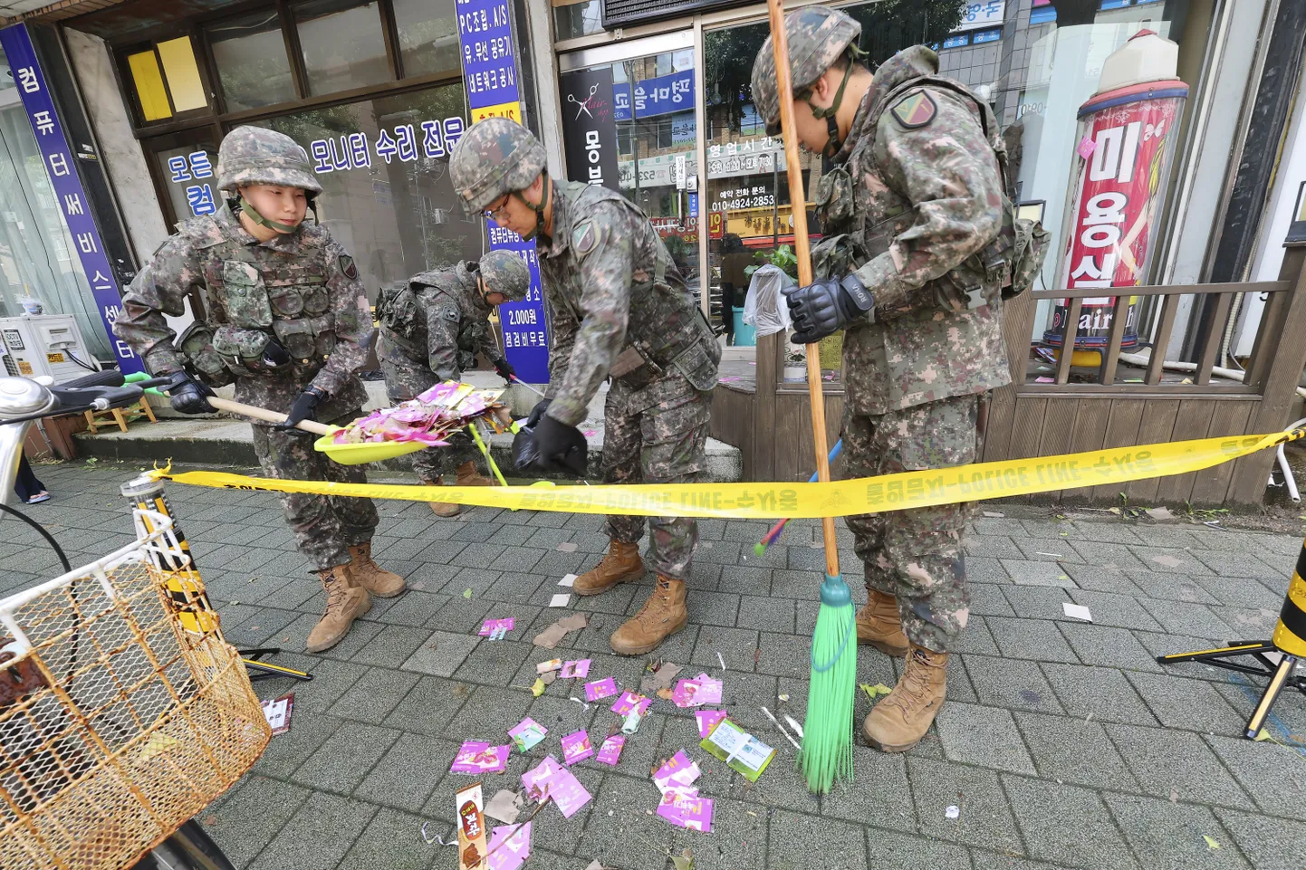Dienvidkorejas militārpersonas uzkopj Ziemeļkorejas palaistā gaisa balona nolaišanās vietu.