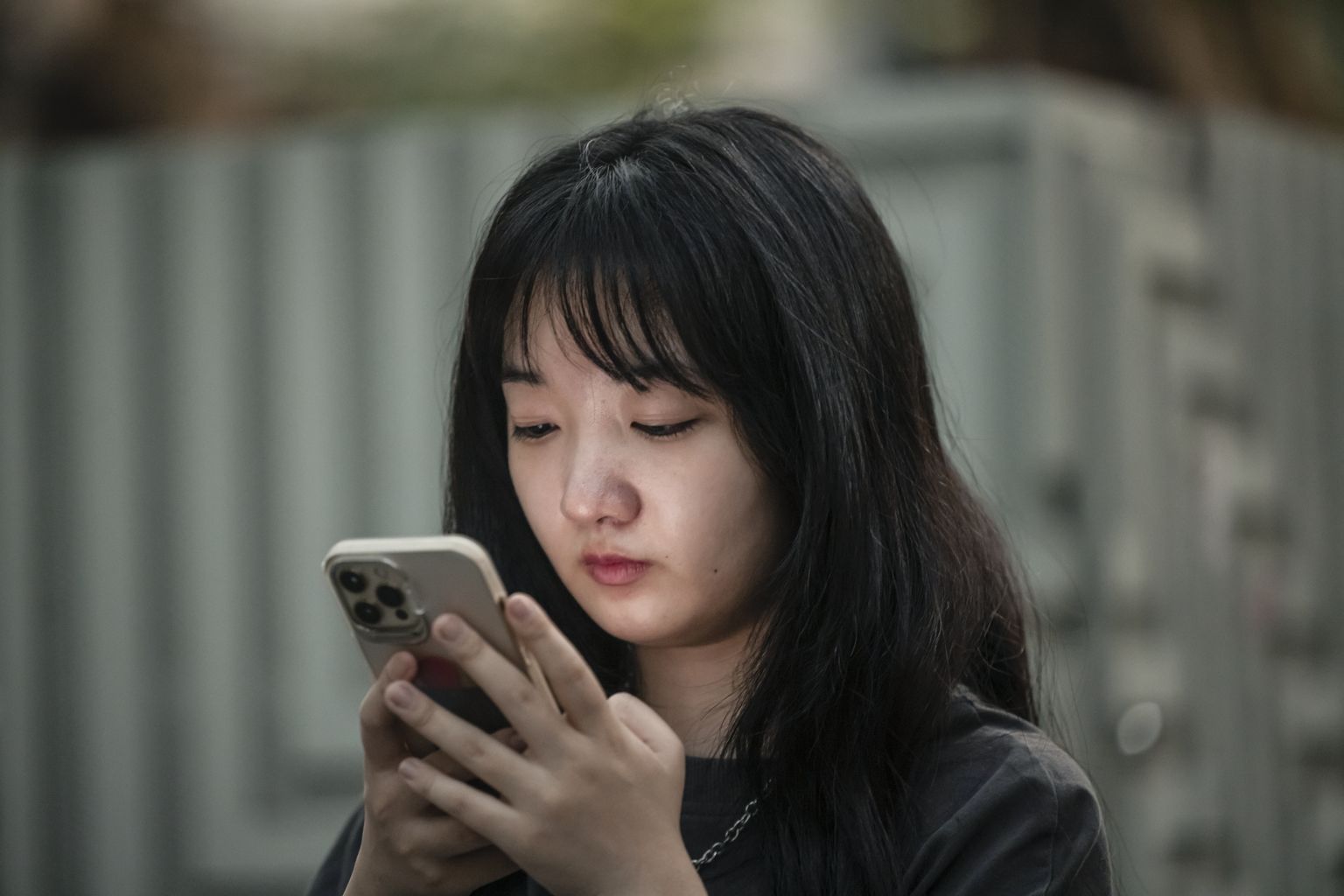 Tütarlaps telefoniga Shanghai tänavatel.