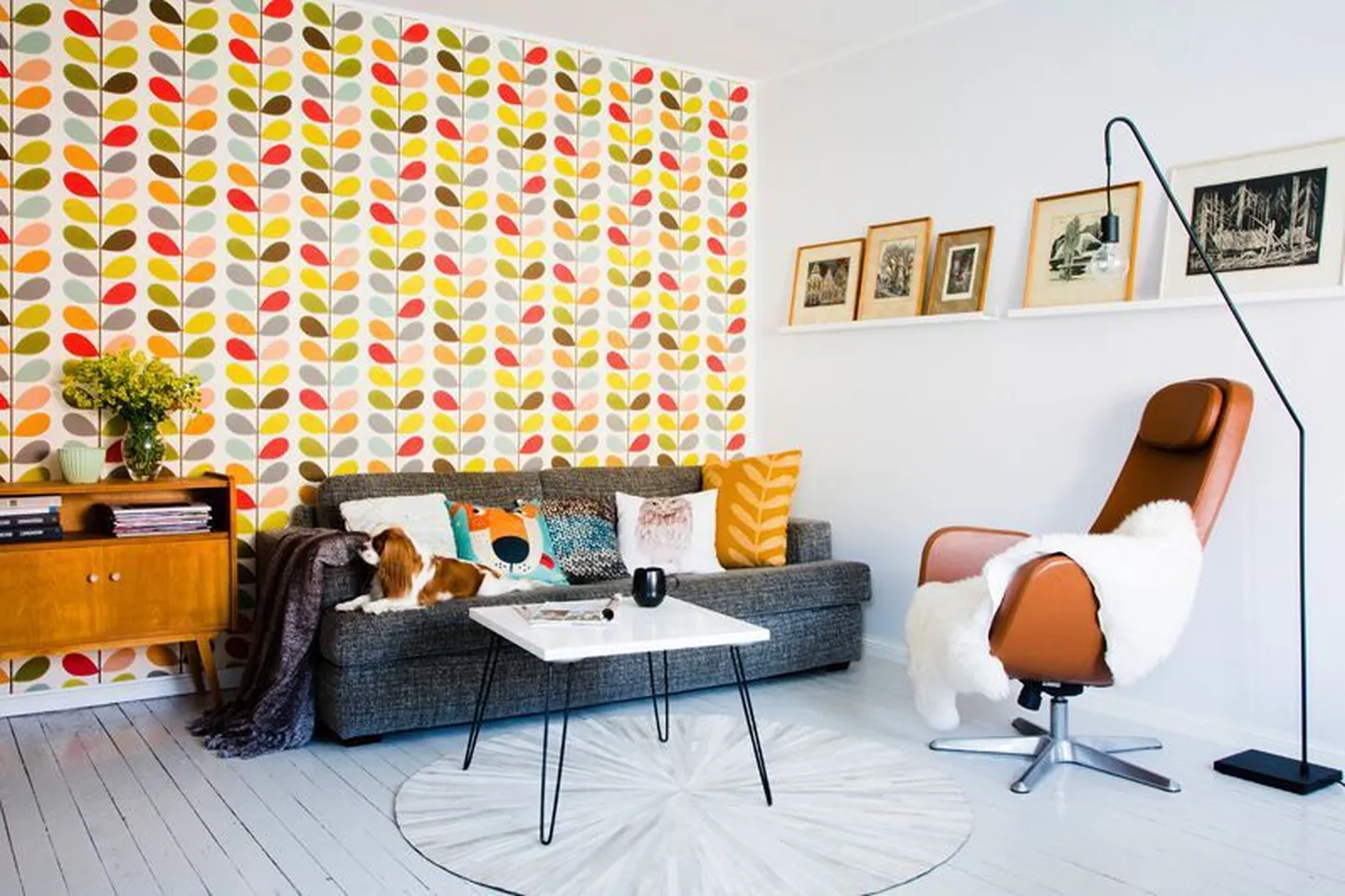 20 m² suurune elutuba mõjub avaralt ja mahutab nii söögilaua kui ka mõnusa sohvanurga. Pildiriiulil on reas Eva kogutud linoollõiked. Seinal Briti tippdisaineri Orla Kiely tapeet salongist Muster.