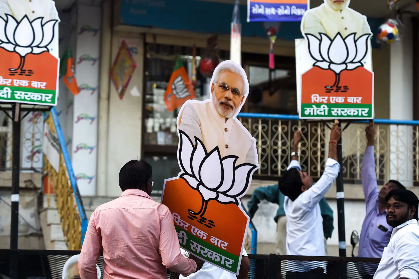 India Ahmedabadi elanikud panevad parlamendivalimiste kolmanda etapi eel oma majale valimisplakatid peaminister Narendra Modi pildiga.