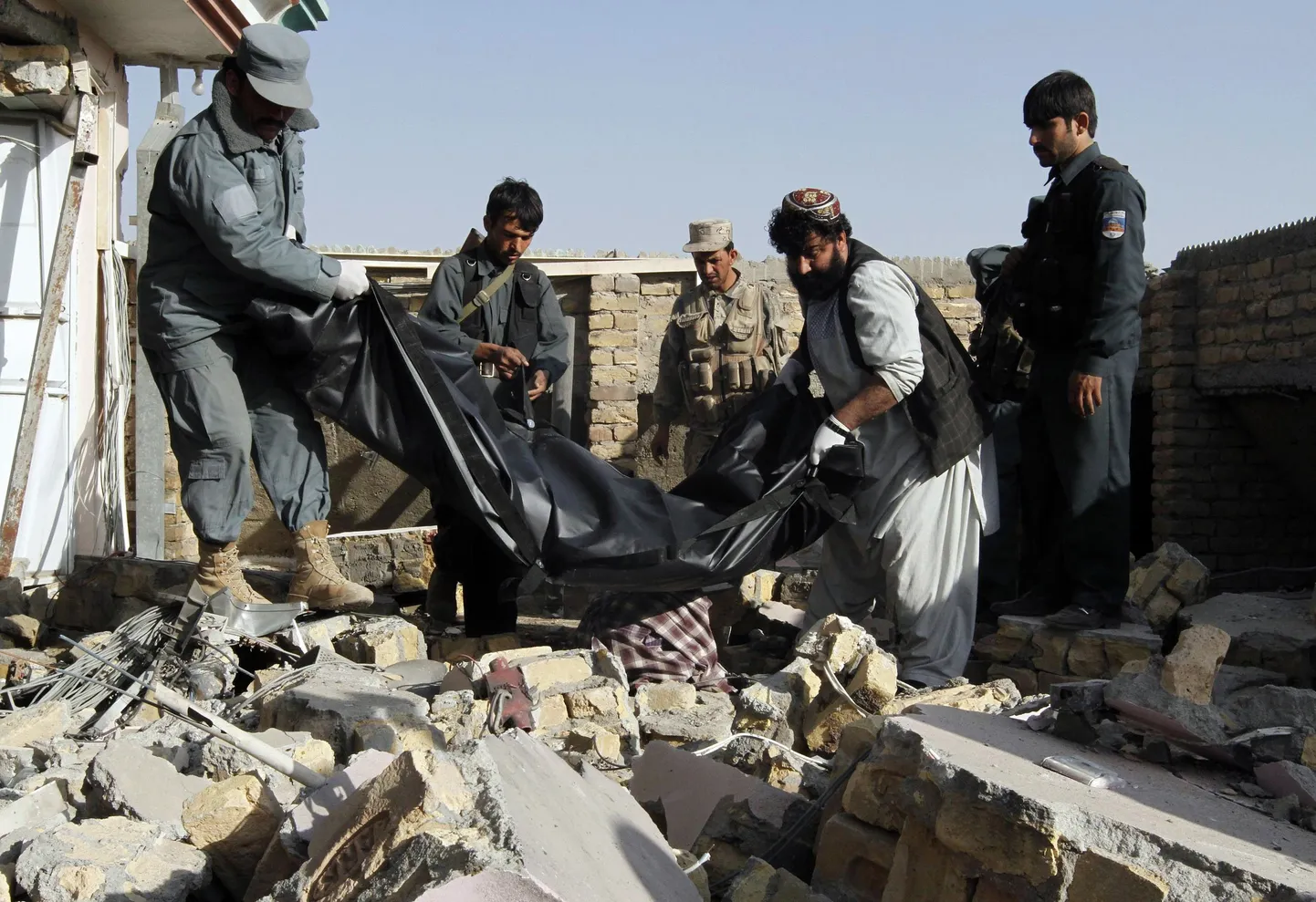 Afgaani politseinikud toimetamas sündmuspaigalt minema suitsiidipommari surnukeha.