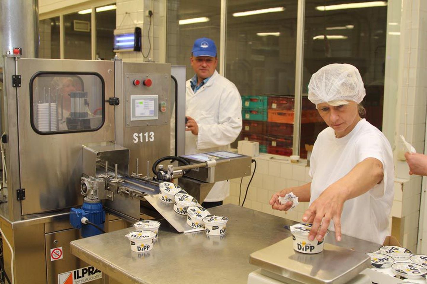ASi Dessert juhataja Anti Rõžikov (vasakul) jälgib, kuidas juustused dipikastmed pakendusmasinast välja tulevad ja kontrollkaalumise läbivad.