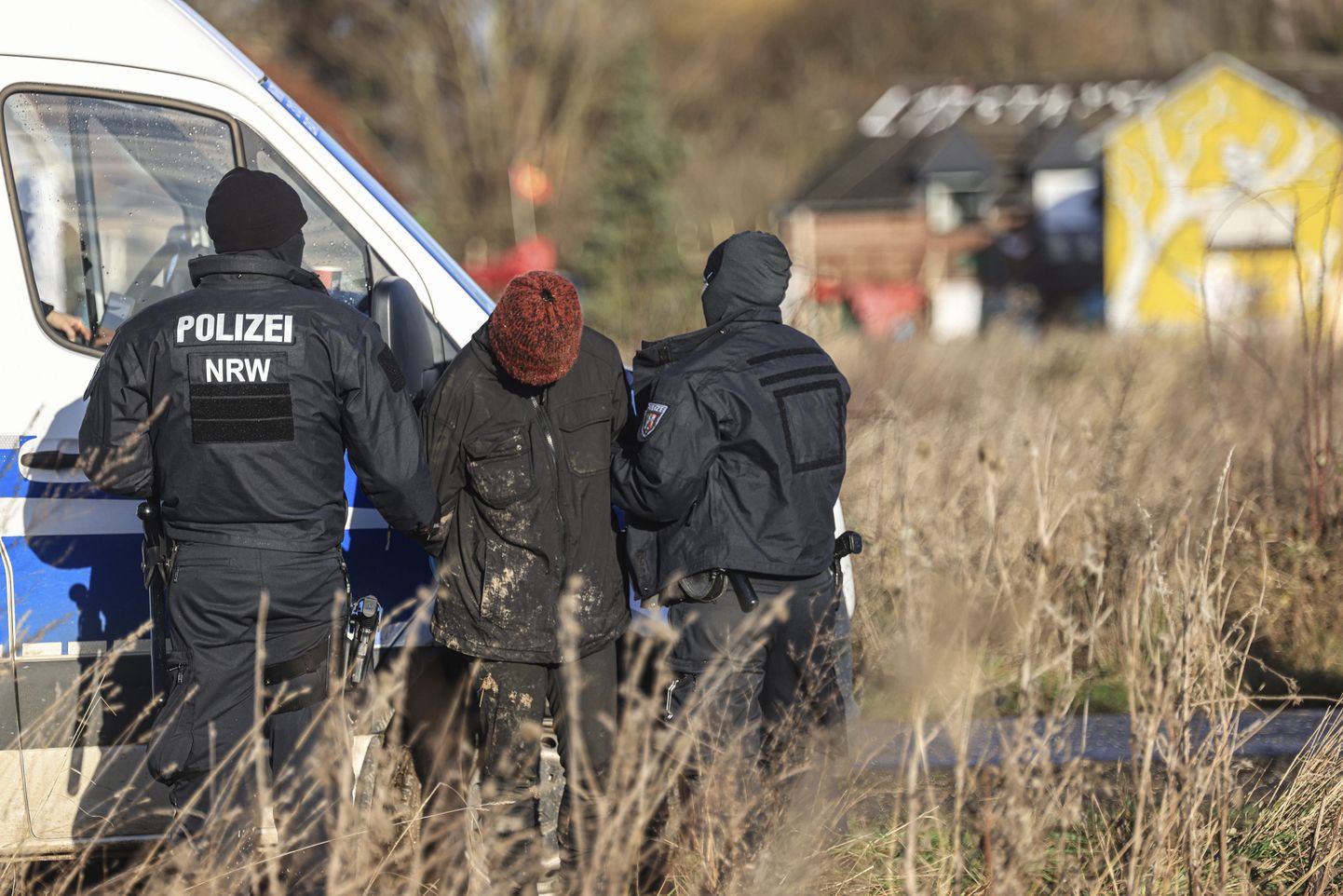 Saksa politseinikud kinni peetud kliimaaktivistiga Lützerathi küla veerel.