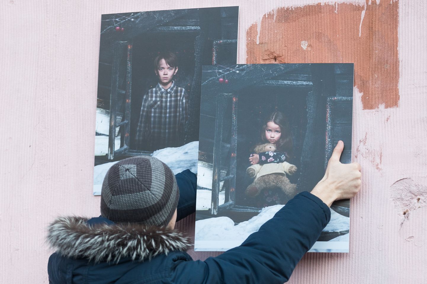 Mees riputamas Kemerovo põlengu ohvrite fotosid kaubanduskeskuse välisseinale.