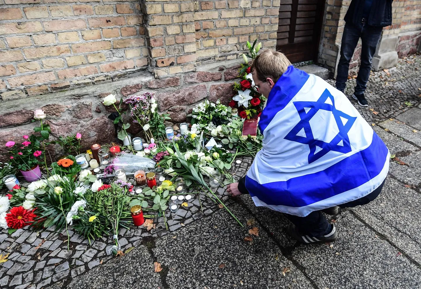 Juudivastased rünnakud Euroopas on viimastel aastatel sagenenud ja uuringute järgi tajub seda ligi 90 protsenti Euroopas elavatest juutidest. Pildil mälestab Iisraeli lipuga mees 2019. aasta oktoobris Saksamaal Halles rünnakus sünangoogile hukkunuid.