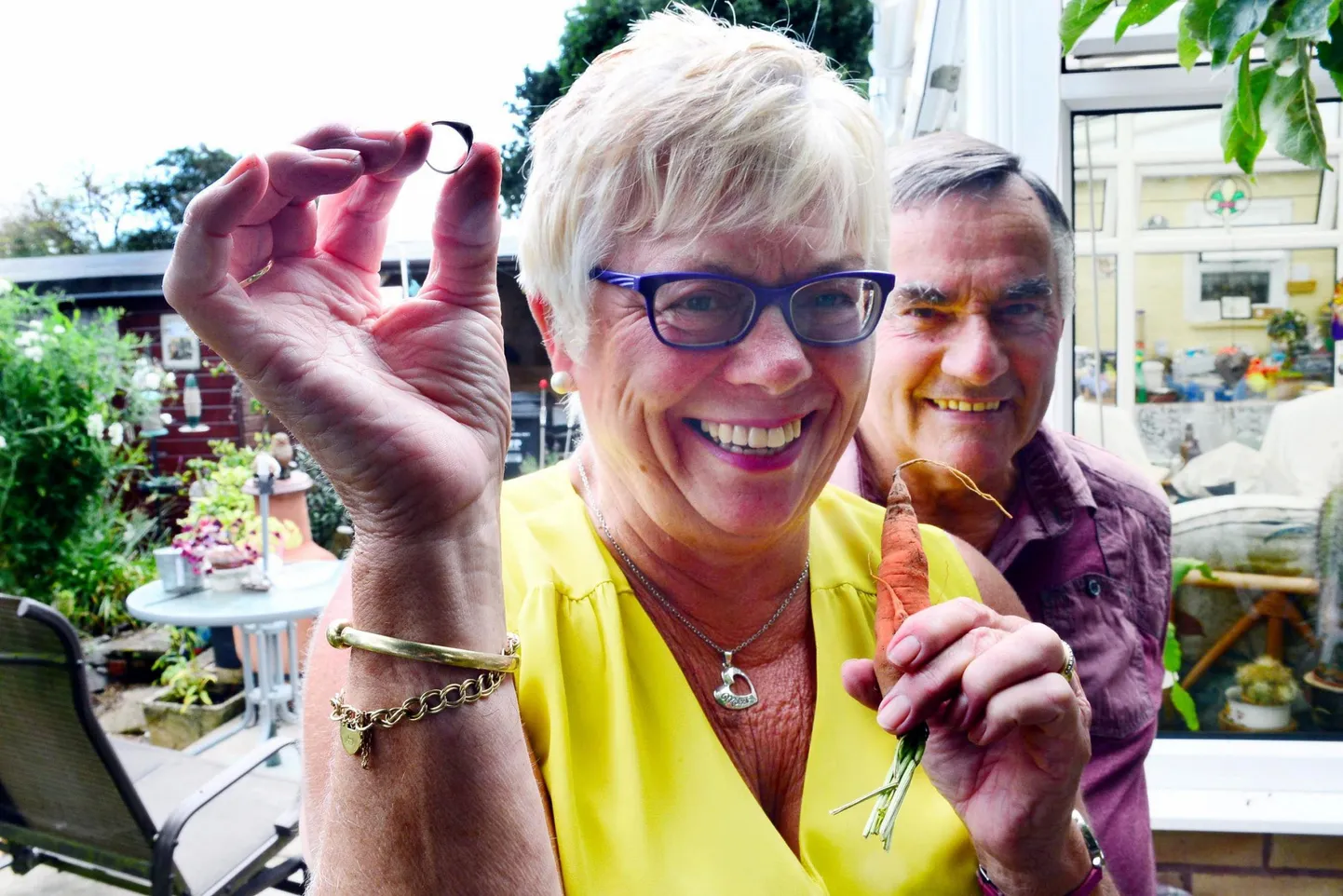 Lin and Dave Keitch reunited with the lost ring. See SWNS story SWCARROTT; A RING lost in its owner's garden 12 years ago has turned up - on a carrott. Lin Keitch couldn't believe her eyes when she spotted the ring for the first time since 2006 after her keen gardener husband Dave dug up some vegetables for lunch. Lin, who was given the gold ring with a heart-shaped amethyst stone by Dave for her 40th birthday, said: "The carrot had grown into the ring. It must be a chance in a million. "Dave dug up the carrots and threw them in a tub outside the back door without noticing anything. "I picked them up and put them in a bowl of water to wash along with some potatoes and then saw the ring in front of me. "It was so amazing. I couldn't believe my eyes. It was great to get my ring back after all those years. "When Dave came in, I said, 'Guess what I've found - look' and he said, 'I've looked for that every time I've done that garden'." It was the couple's daughter, Sarah, now 37, who actually lost the item of jewellery in their garden in School Road, Monkton Heathfield.