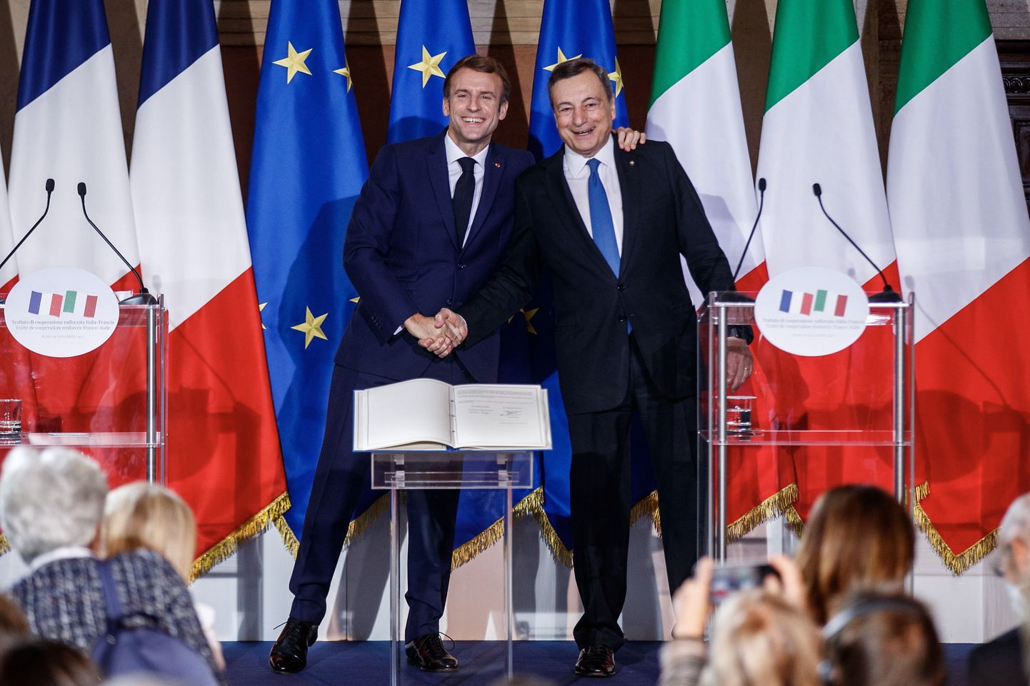 Prantsuse president Emmanuel Macron (vasakul) ja Itaalia peaminister Mario Draghi reedel Roomas värskelt allkirjastatud leppe taustal naeratamas ja kätlemas.