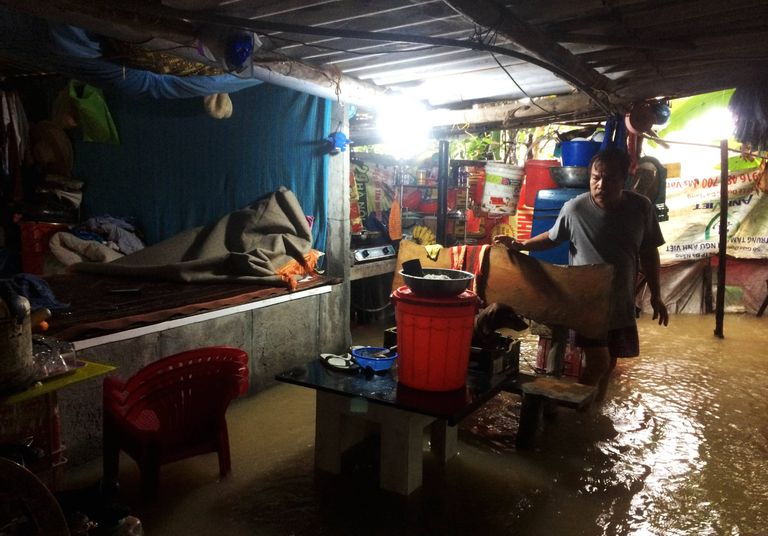 Kohalik mees vaatab üle üleujutustes kahjustada saanud vara.