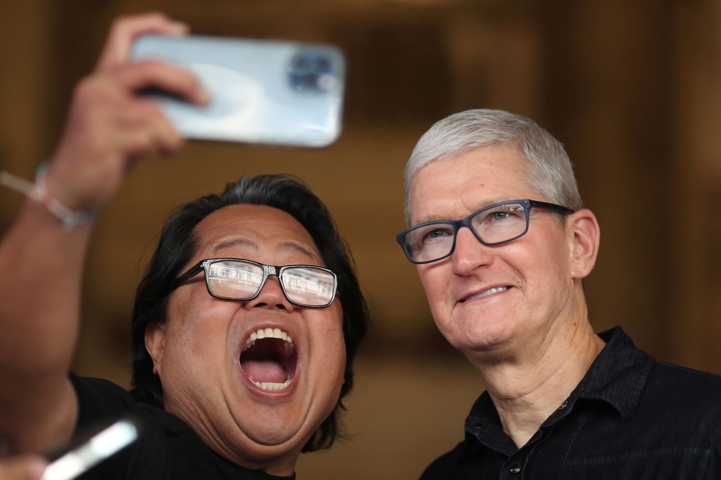 Apple CEO Tim Cook poses for a selfie with a visitor at the new Apple Store on Broadway in downtown Los Angeles, California, U.S., June 24, 2021. REUTERS/Lucy Nicholson