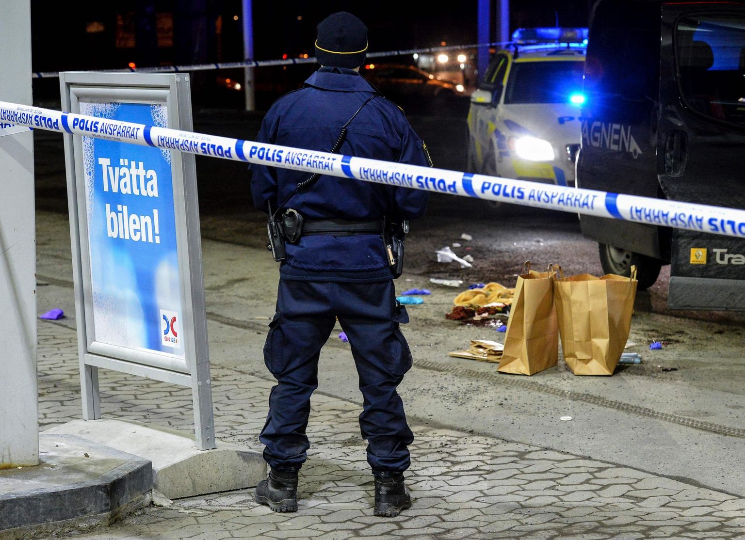 Politseinik valvamas Stockholmi lähedal Botkyrka vallas Fittjas paika, kus tulistati meest. Vald on pikalt olnud kimpus kuritegelike jõukudega. 