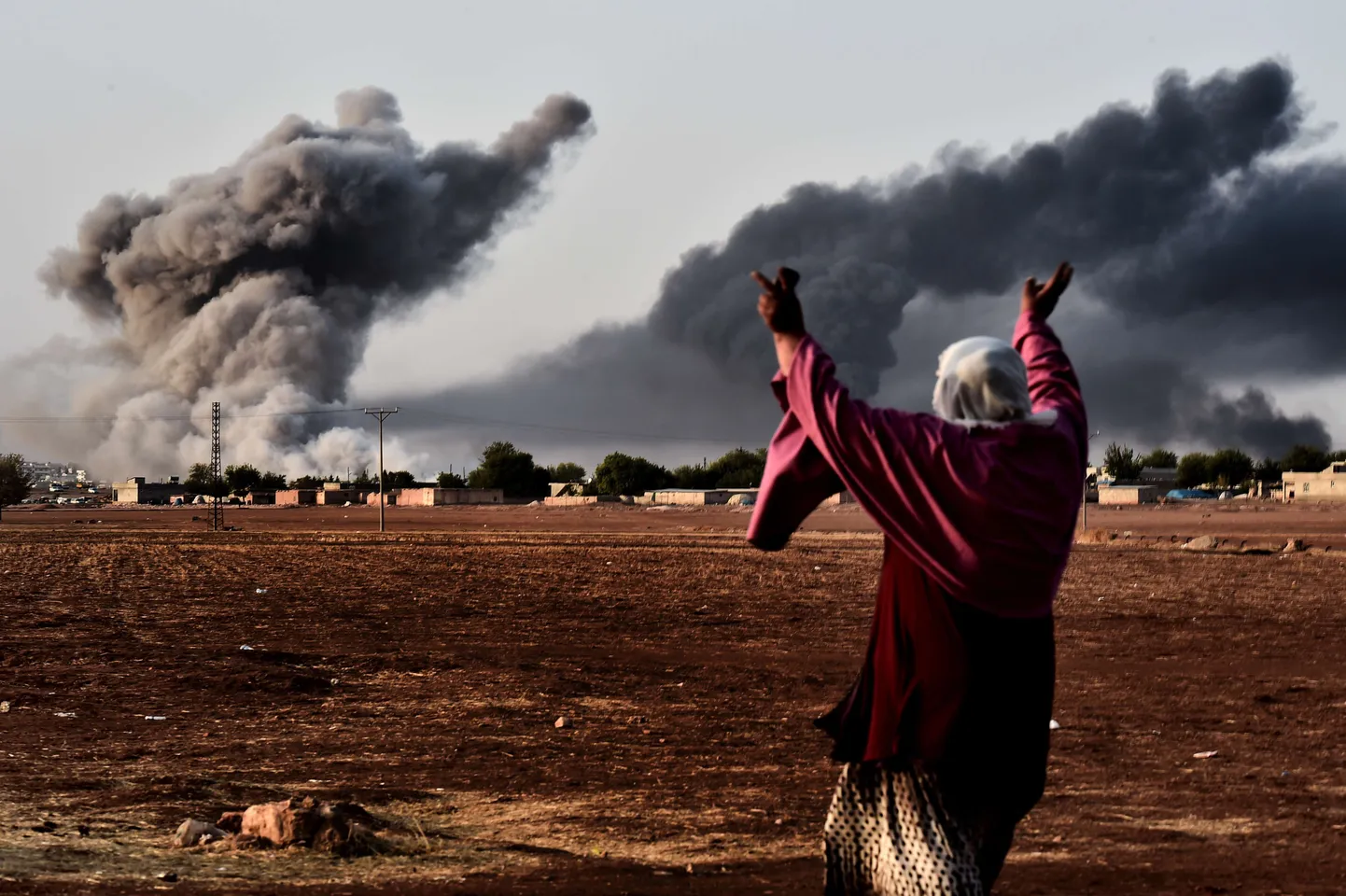 Naine täna Türgi-Süüria piirialal asuvas Mursitpinari külas Kobane pihta tehtud õhulöögile reageerimas.